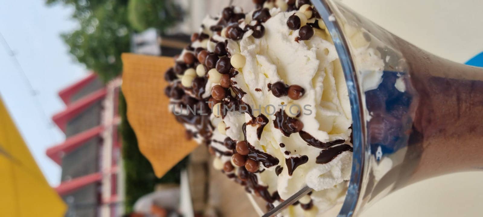 Close-up view of a chocolate sundae topped with whipped cream and chocolate chips