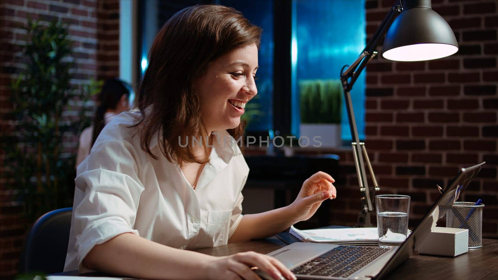 Woman in office celebrating finalizing deal with business partners, happy about incoming salary bonus. Employee in workplace dancing on chair after closing agreement with B2B clients, camera A