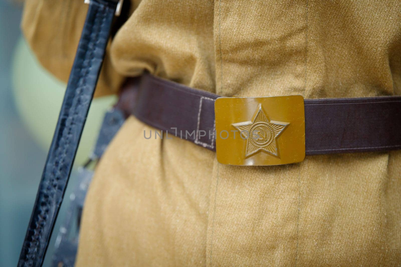 A soldier's buckle with the emblem of a star, hammer and sickle, worn in honor of the Great Victory Day on May 9, close up by Rom4ek