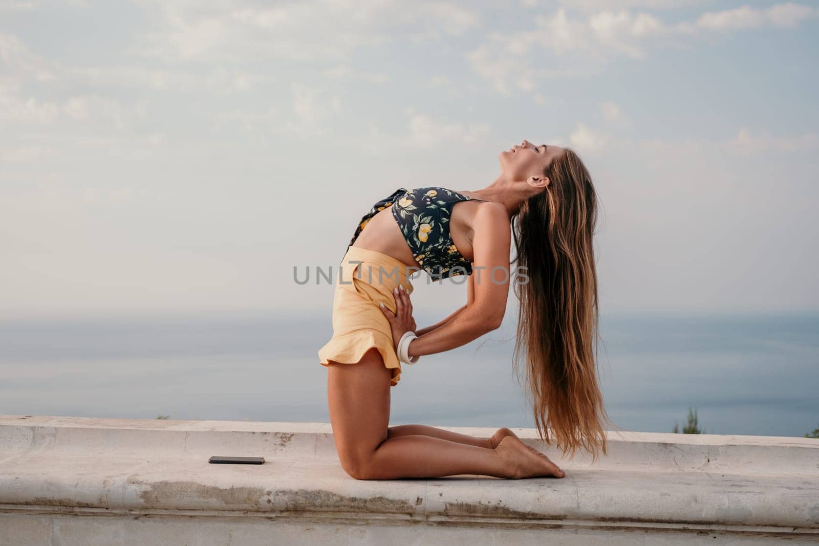 Woman park yoga. Side view of free calm bliss satisfied woman with long hair standing in morning park with yoga position against of sky by the sea. Healthy lifestyle outdoors in park, fitness concept. by panophotograph