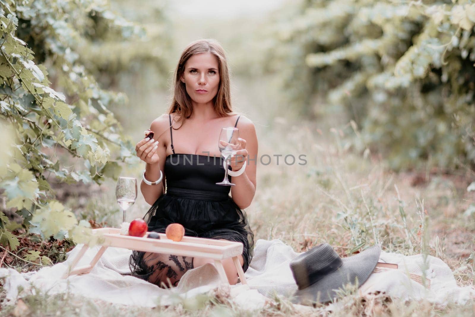 Picnic and wine tasting at sunset in the hills of Italy, Tuscany. Vineyards and open nature in the summer. Romantic dinner, fruit and wine.