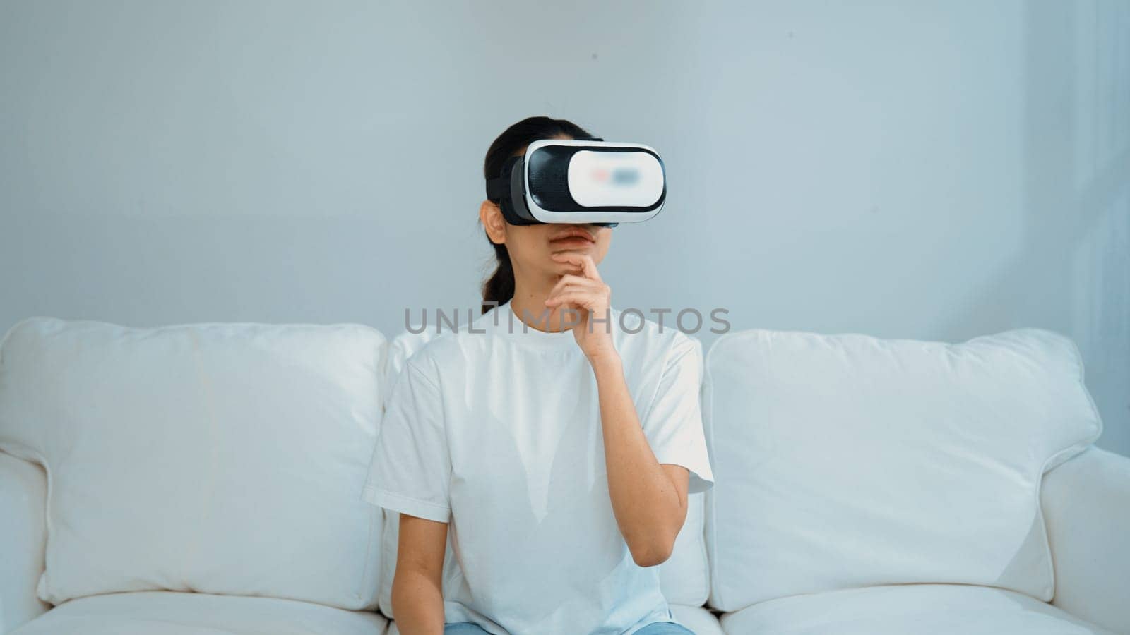 Young woman using virtual reality VR goggle at home for vivancy experience by biancoblue