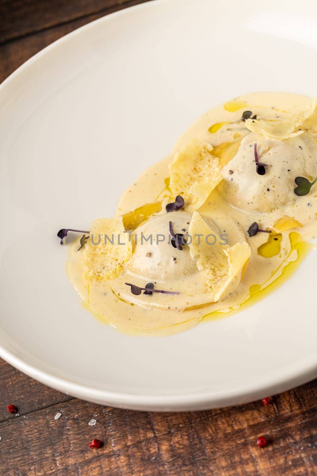 Cheese ravioli with sauces on a white porcelain plate by Sonat