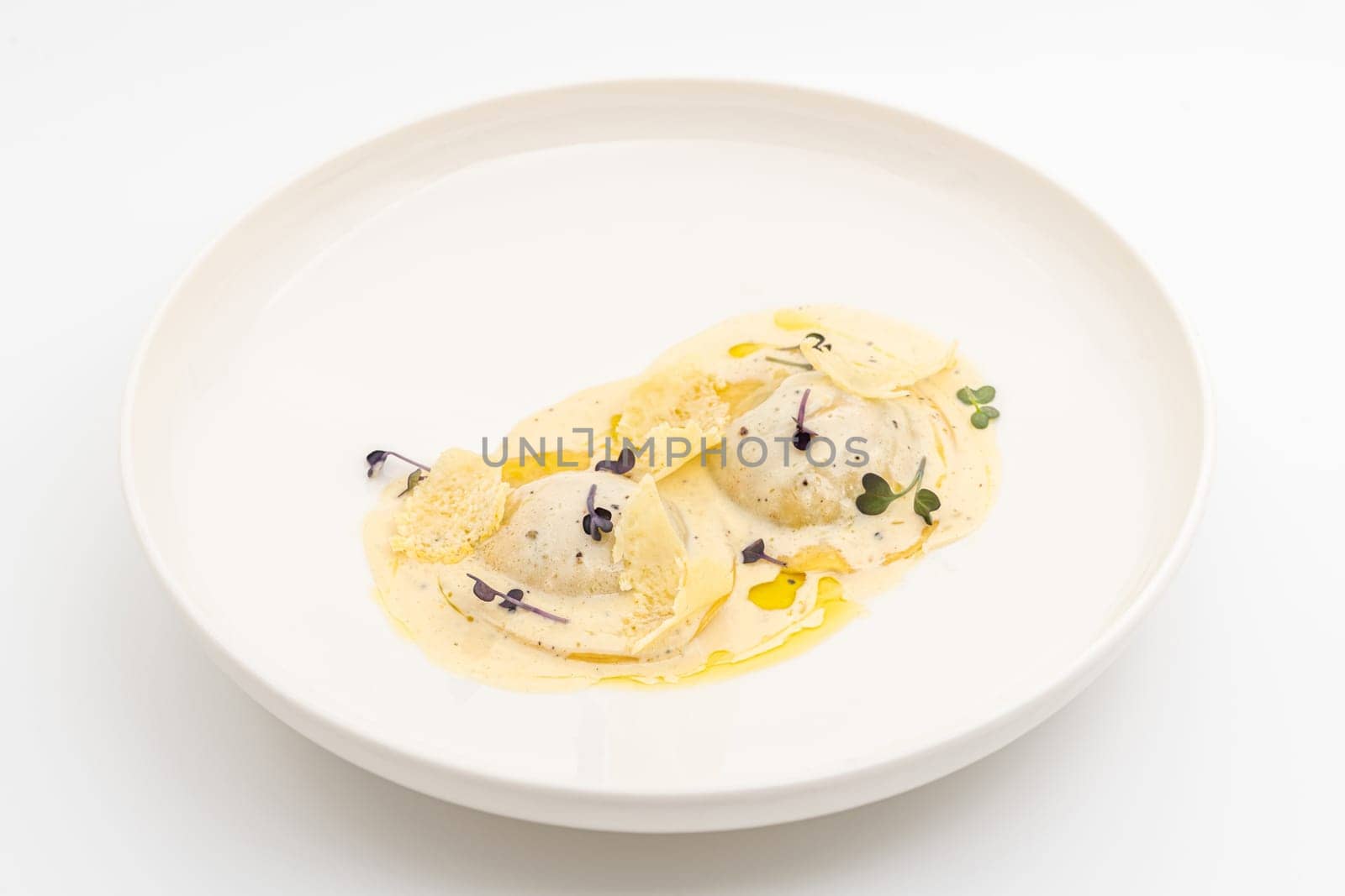 Cheese ravioli with sauces on a white porcelain plate by Sonat