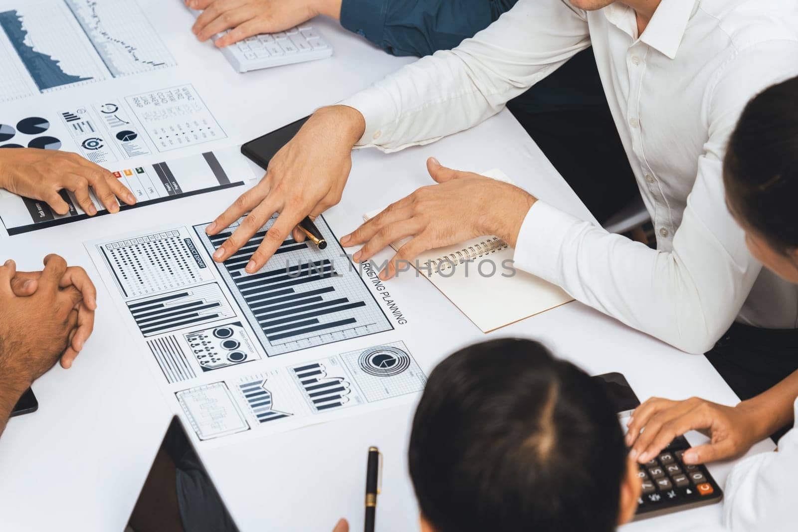 Analyst team utilizing BI Fintech to analyze financial data at table in meeting room. Businesspeople analyzing BI dashboard power on paper for business insight and strategic marketing planning.Prudent