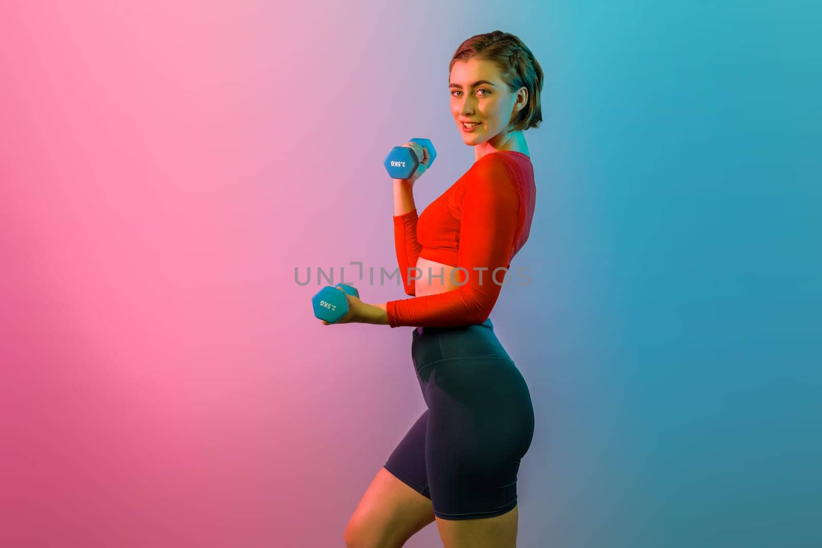 Full body length gaiety shot athletic and sporty woman with dumbbell for weight lifting as bodybuilding exercise in standing posture on isolated background. Healthy active and body care lifestyle