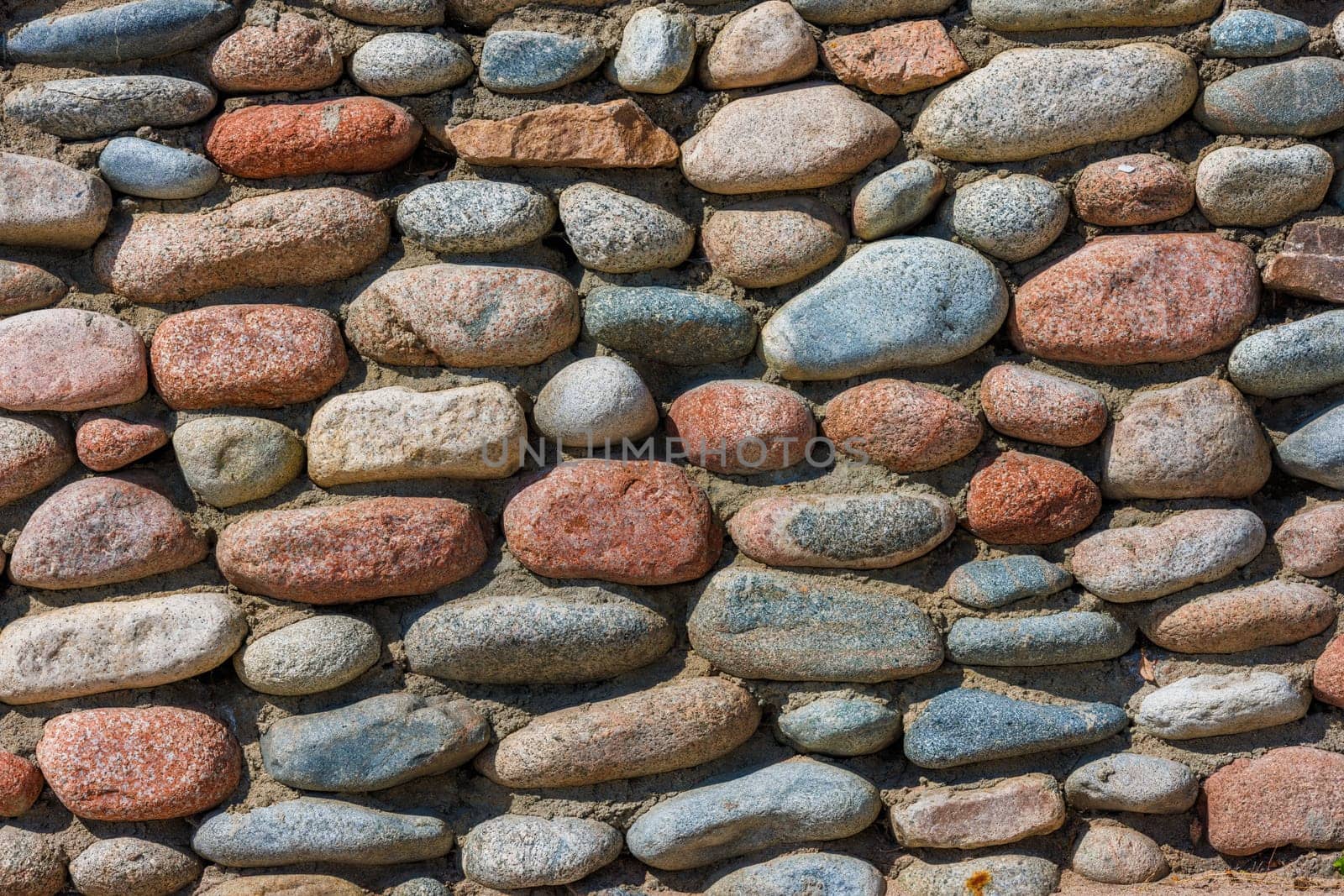wall made of many colorful round stones, full-frame background and texture by z1b