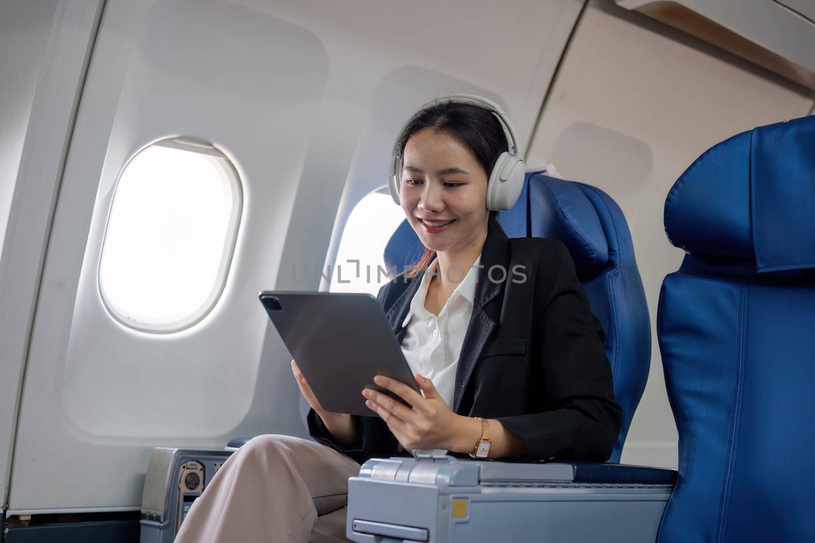 A young business woman travels to work outside the city by flying in business class. and work on airplanes with tablets.