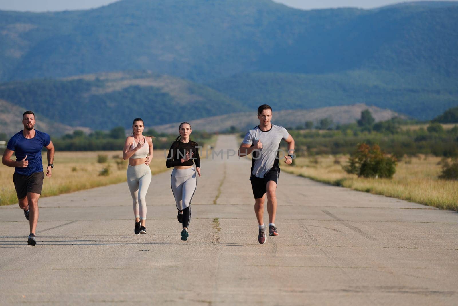 A group of friends maintains a healthy lifestyle by running outdoors on a sunny day, bonding over fitness and enjoying the energizing effects of exercise and nature by dotshock