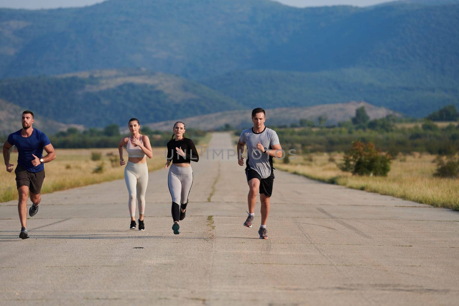 A group of friends maintains a healthy lifestyle by running outdoors on a sunny day, bonding over fitness and enjoying the energizing effects of exercise and nature by dotshock