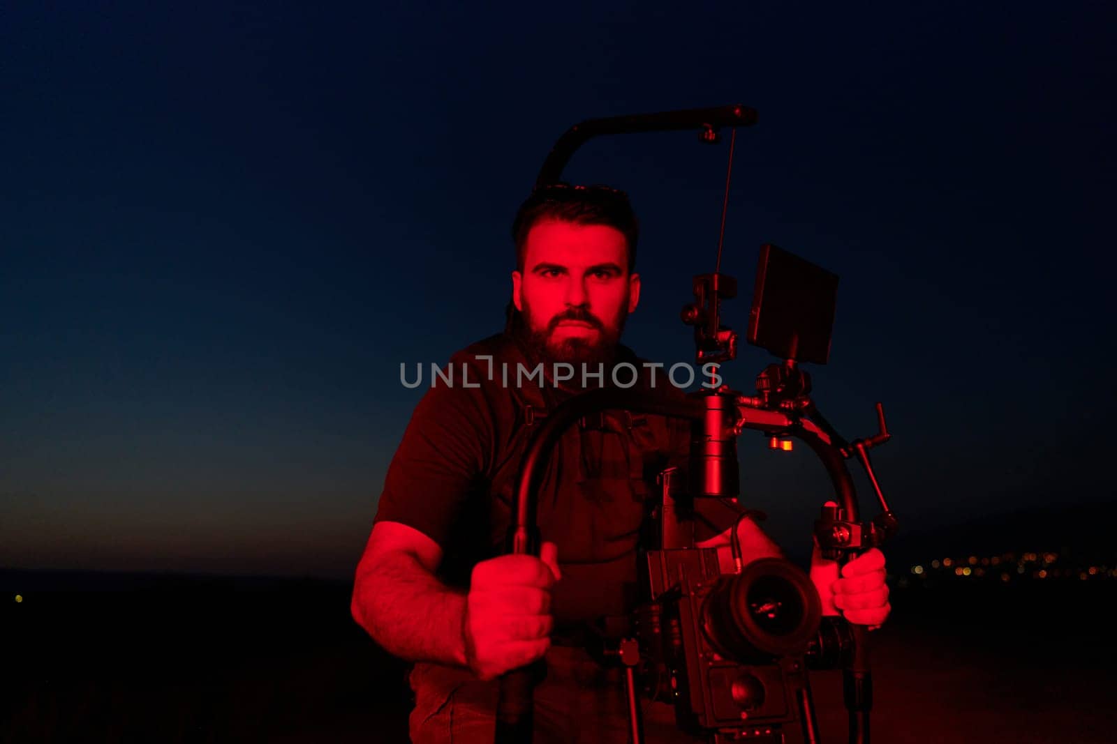 A skilled videographer captures the intensity of athletes running, illuminated by vibrant red lights, encapsulating the energy and determination of their nighttime training session.