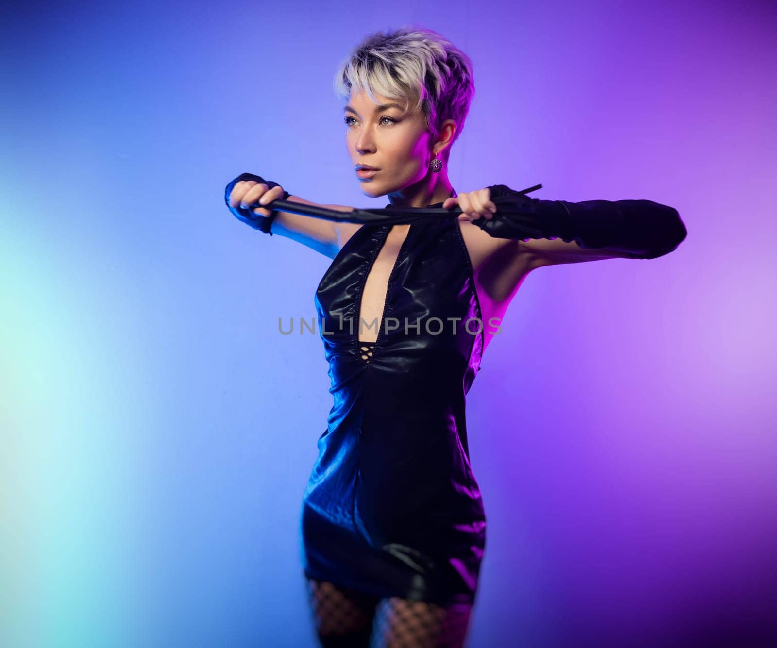 sexy girl in erotic bdsm image mistress in latex dress posing in front of a copy paste neon background by Rotozey