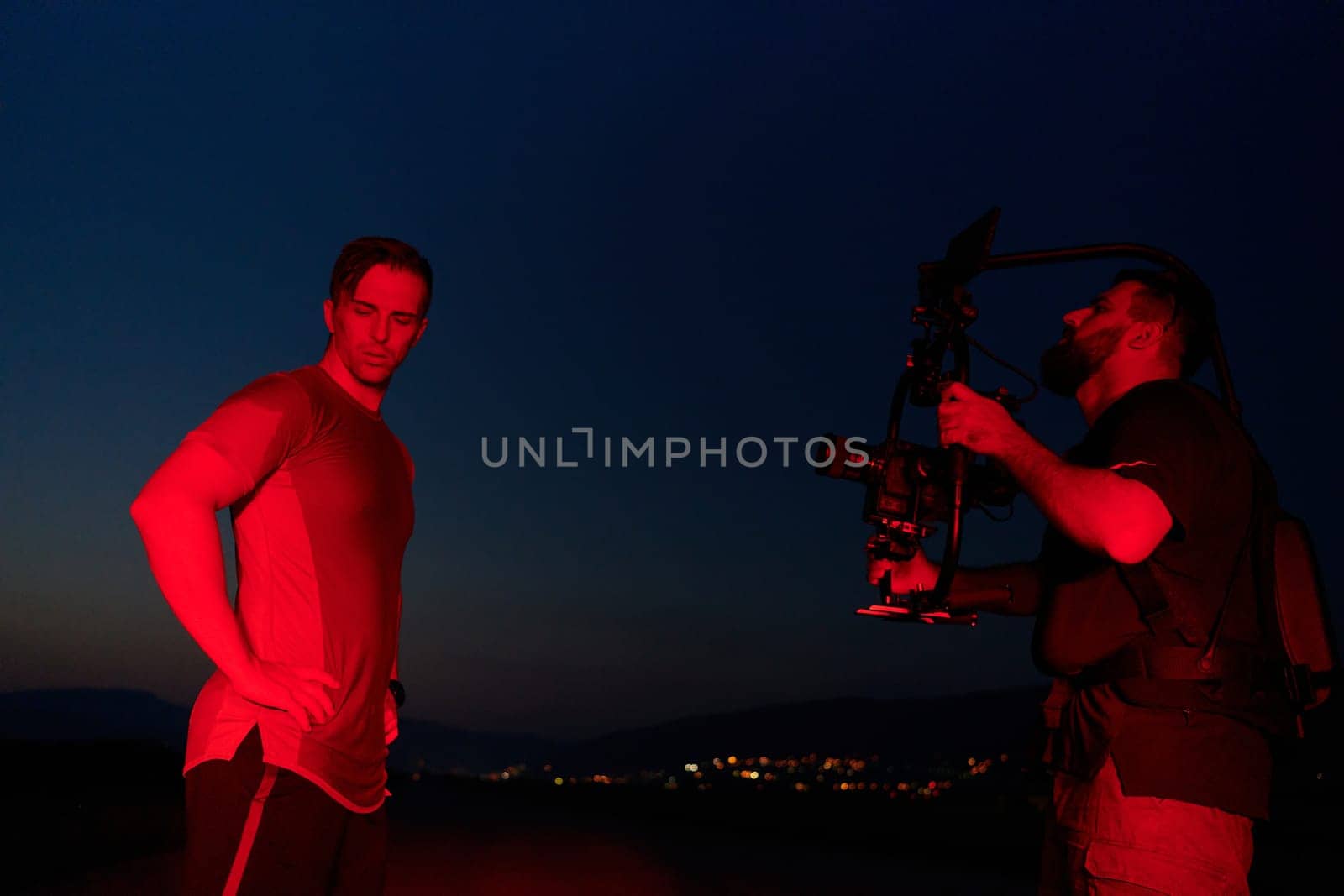 Nighttime Capture: Professional Videographer Films Athletes Running in Red-Lit Darkness by dotshock