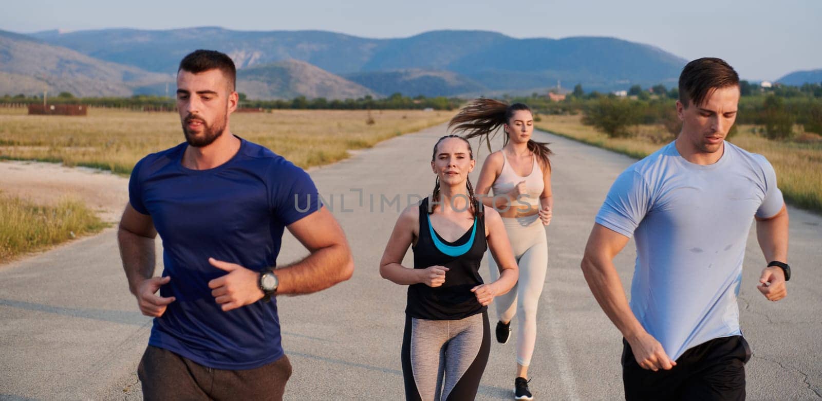 A group of friends maintains a healthy lifestyle by running outdoors on a sunny day, bonding over fitness and enjoying the energizing effects of exercise and nature by dotshock