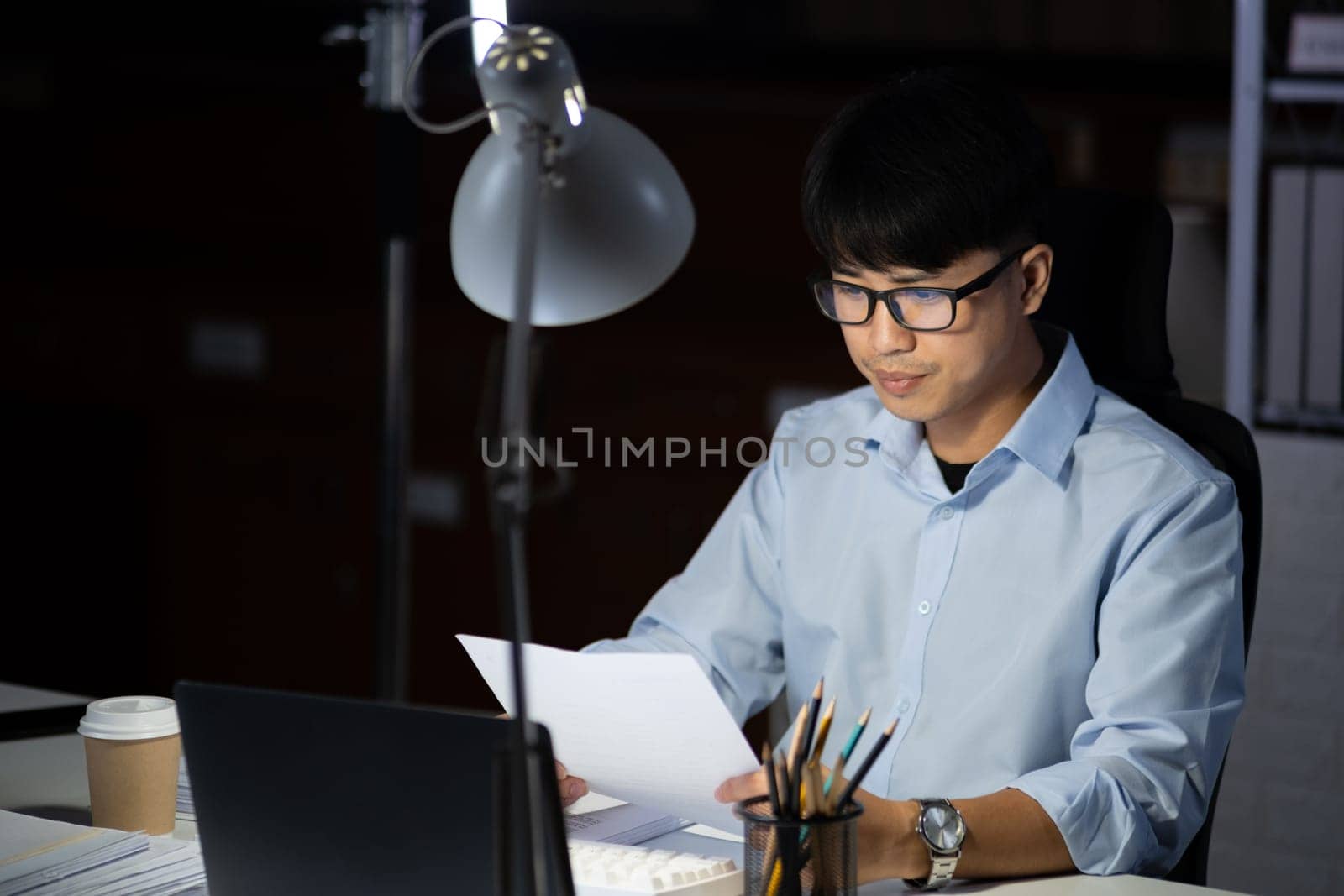 Businessman working hard overtime at night at the office. He felt tired and stressed from work.