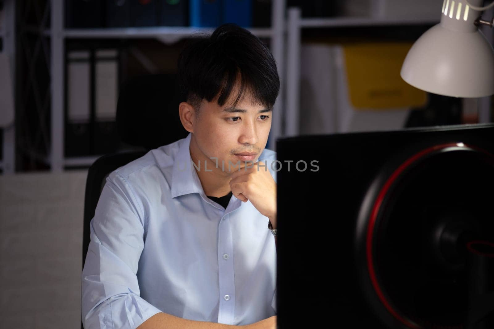 Businessman working hard overtime at night at the office. He felt tired and stressed from work.