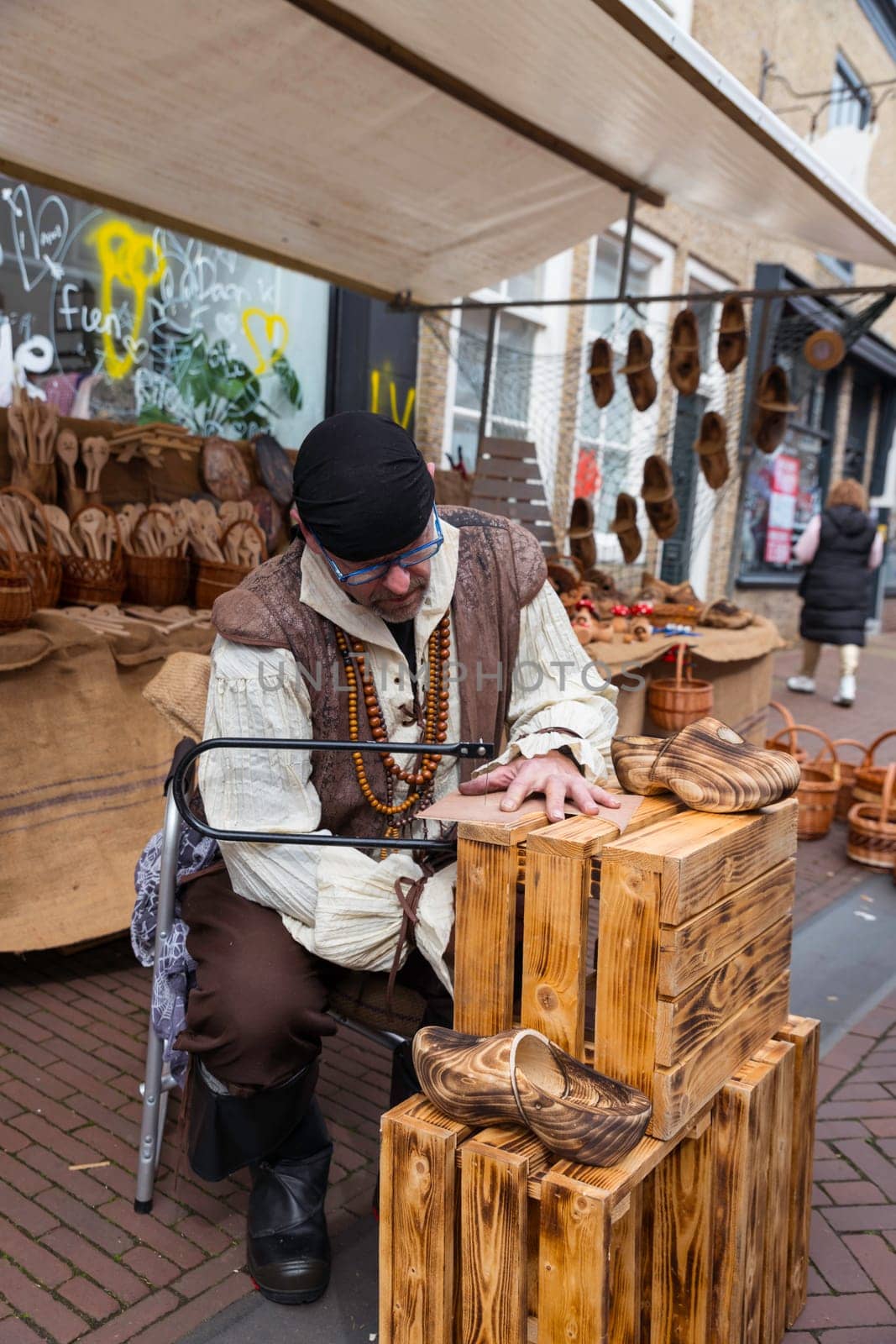 Brielle,Holland,1-04-2024:a man in traditional costume is engaged in wood carving during the celebration of the the first town to be liberated from the Spanish in Den Briel in the Netherlands