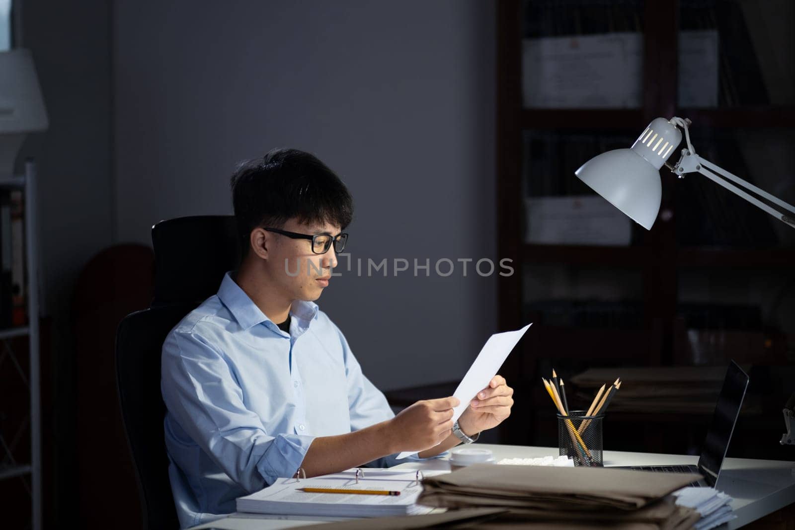 Businessman working hard overtime at night at the office. He felt tired and stressed from work.