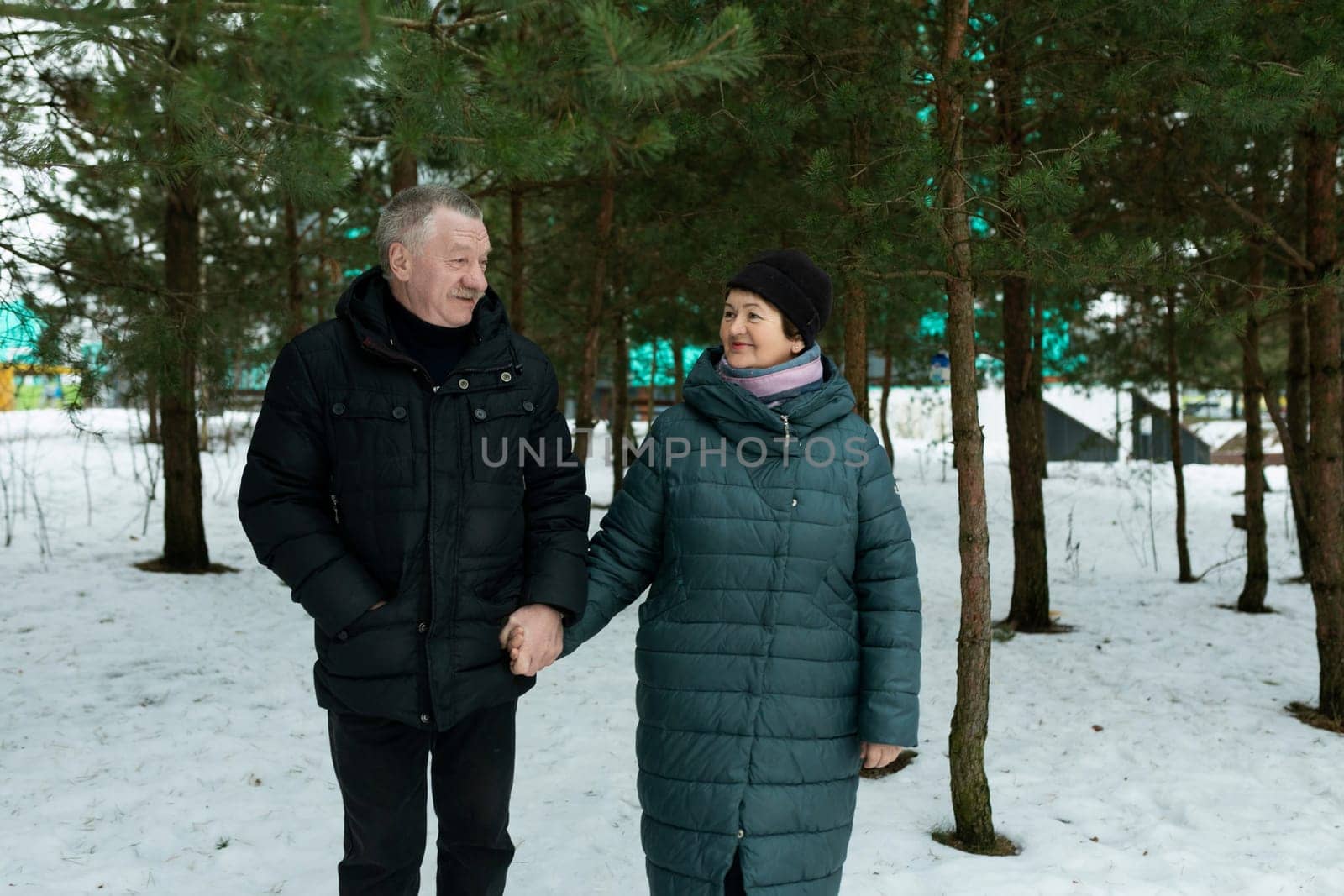 Cute retired couple going for a walk and holding hands together by TRMK