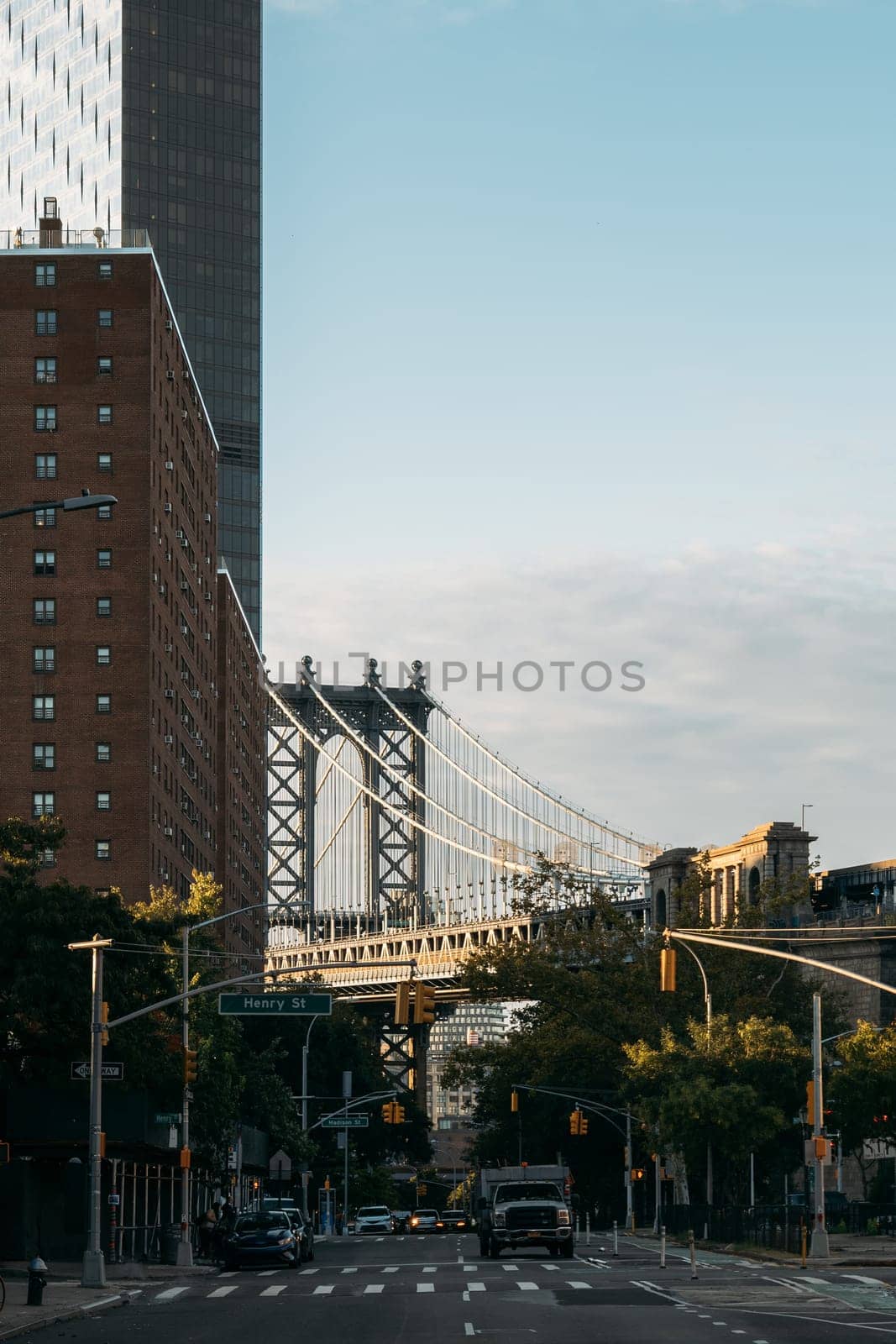 A view of the Manhattan Bridge spanning above a New York street scene.