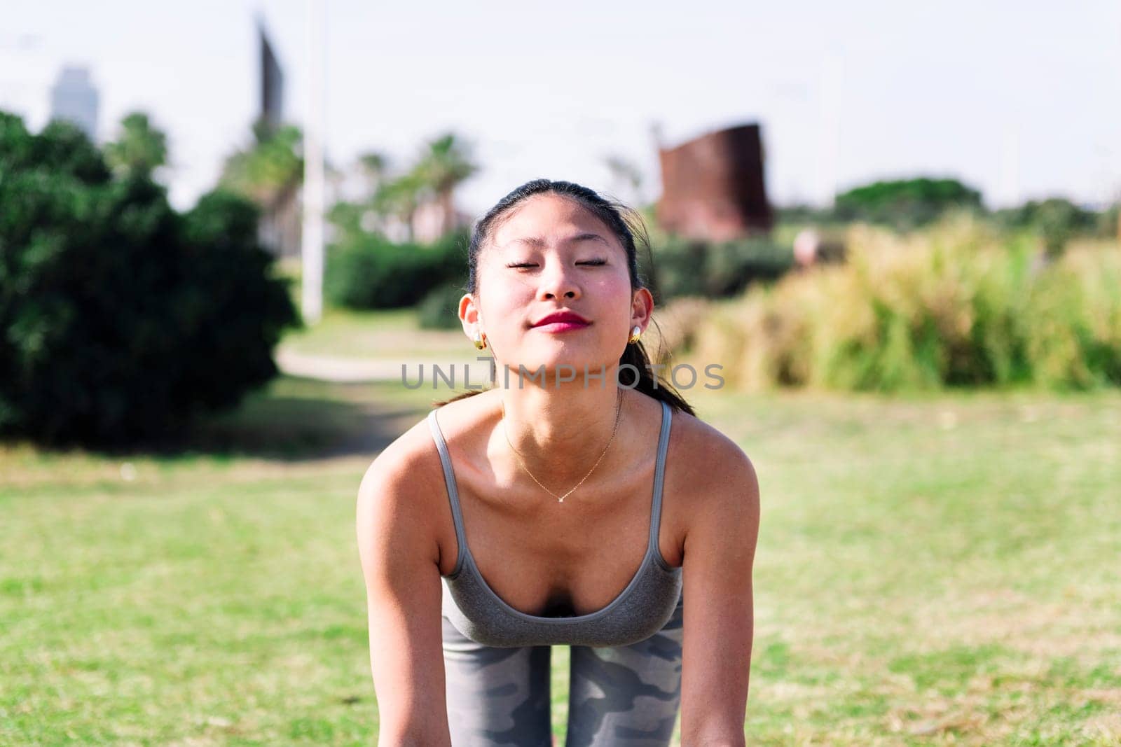 woman doing yoga stretching exercises in park by raulmelldo