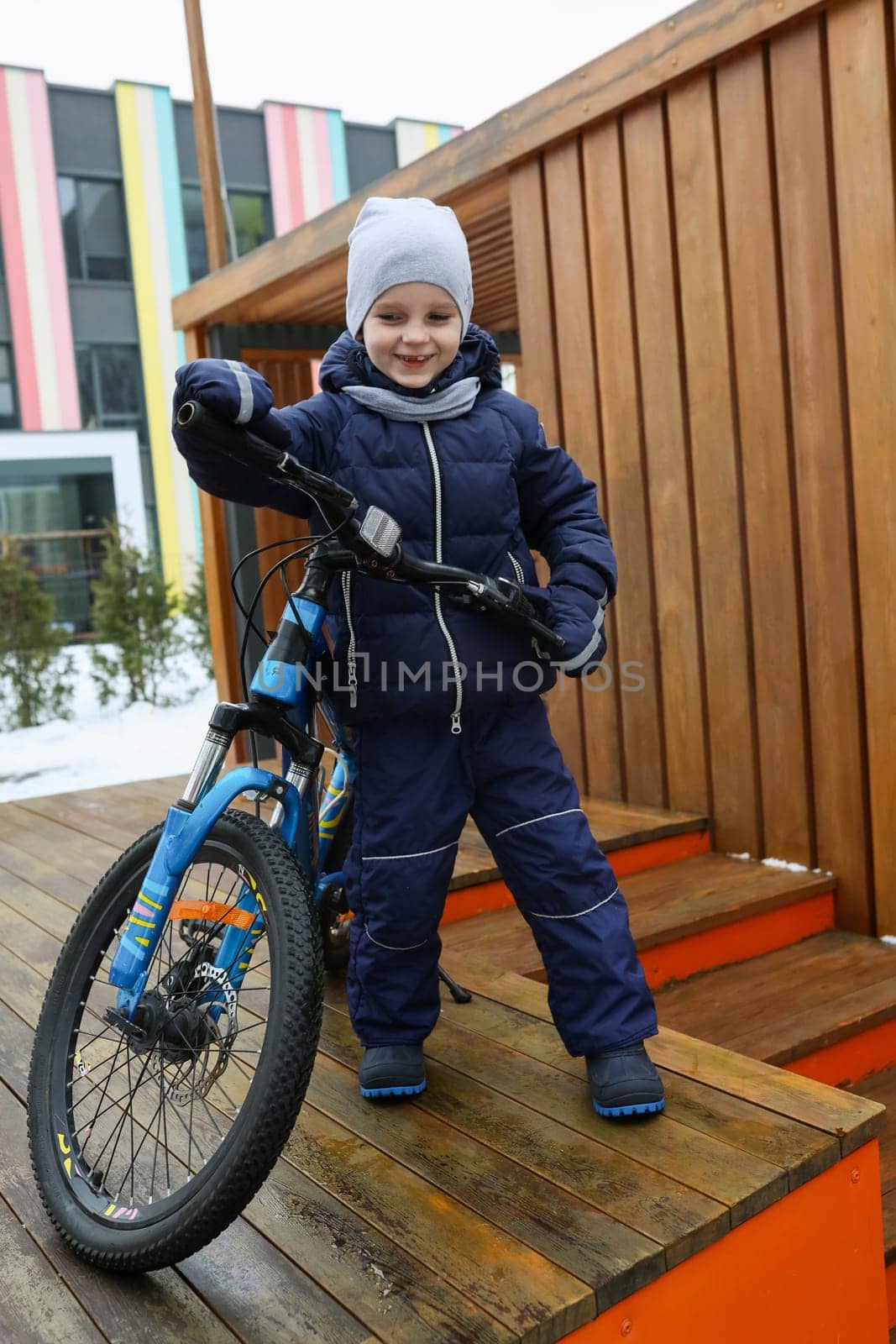 Child boy riding a bike in winter by TRMK