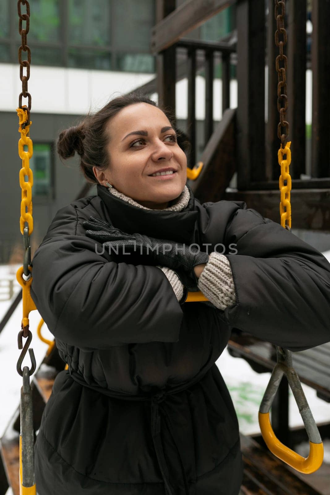 Lifestyle concept, carefree brunette woman in a black winter jacket walking on the playground by TRMK