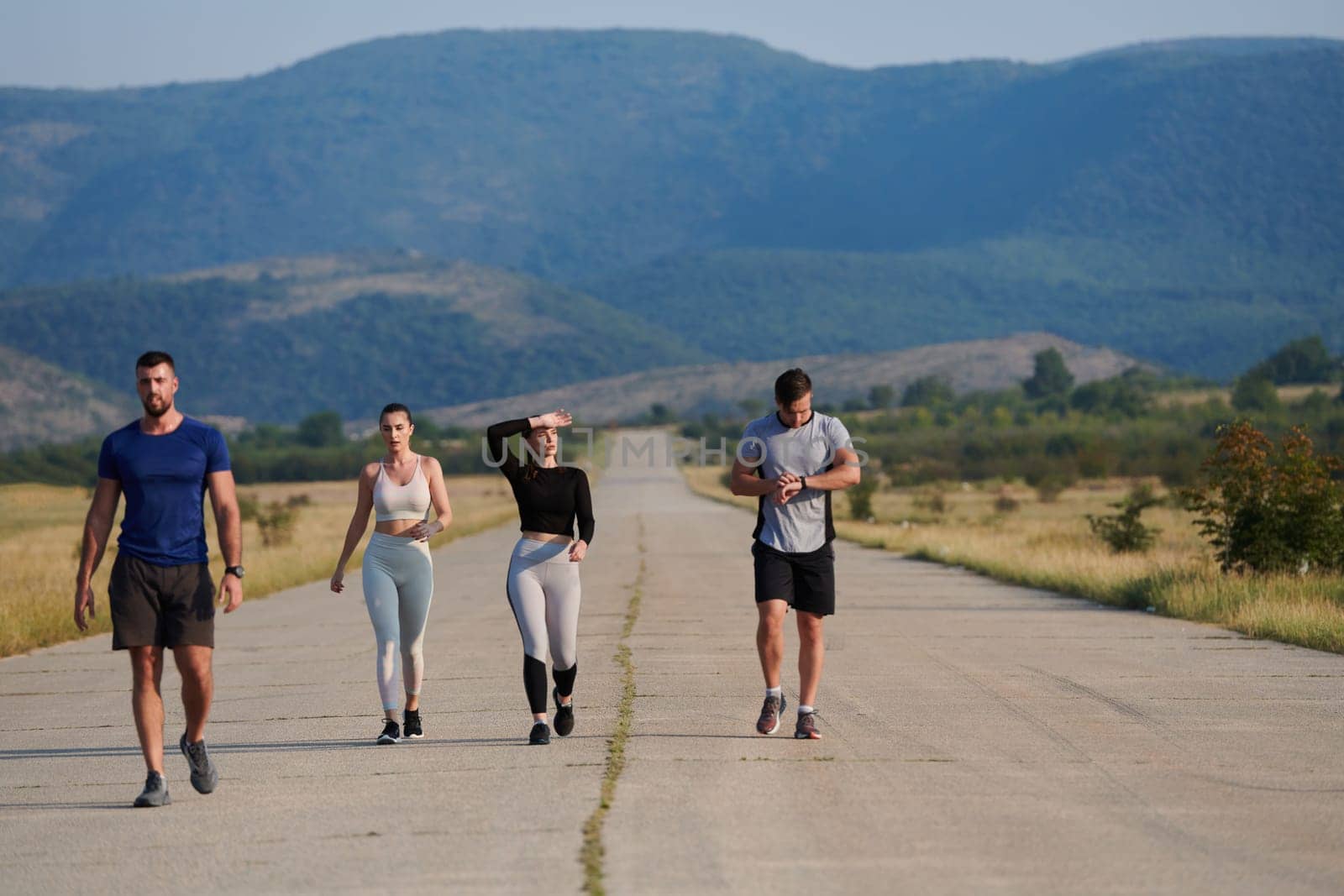 A group of friends maintains a healthy lifestyle by running outdoors on a sunny day, bonding over fitness and enjoying the energizing effects of exercise and nature by dotshock