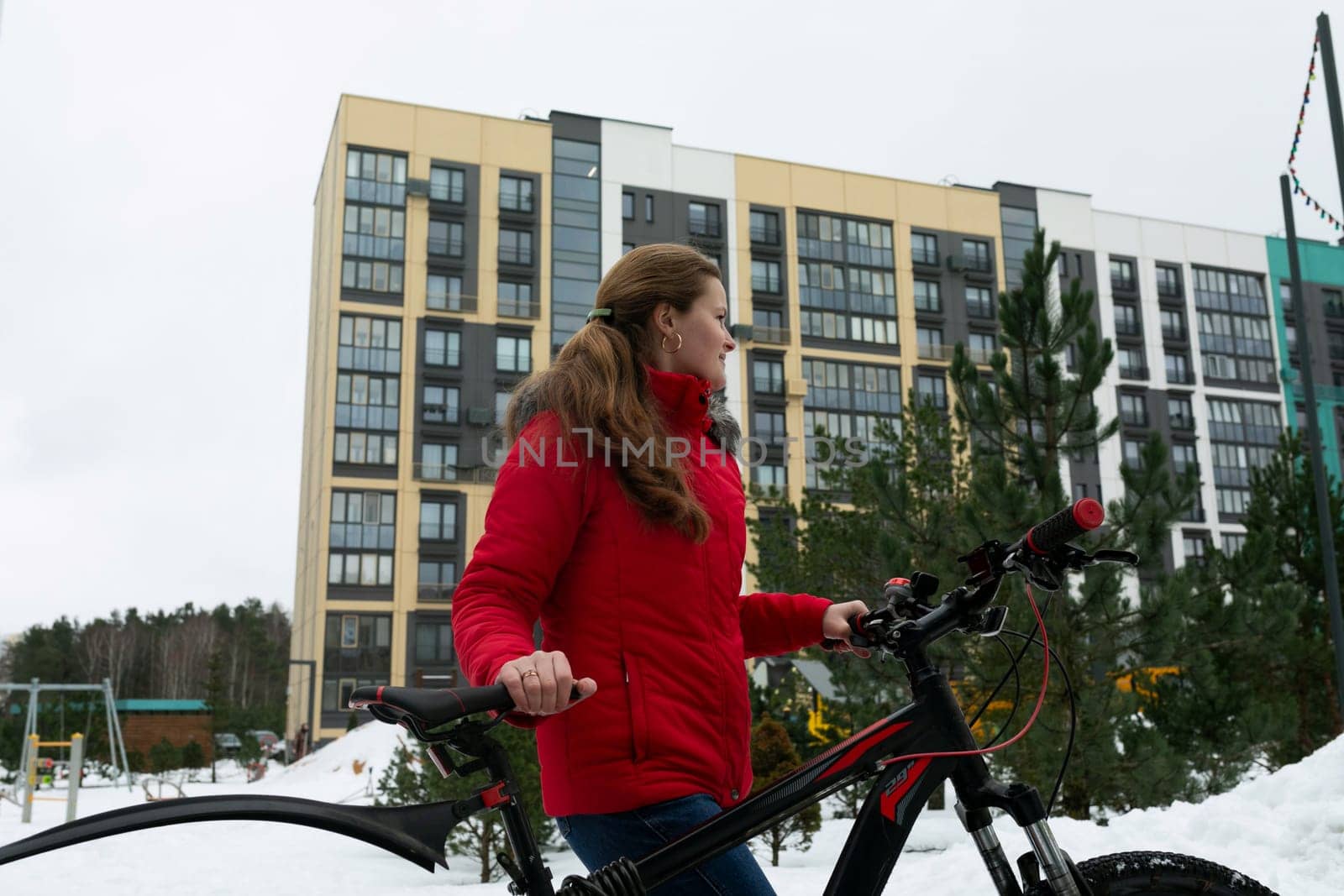 Active European woman in a red jacket rented a bicycle.