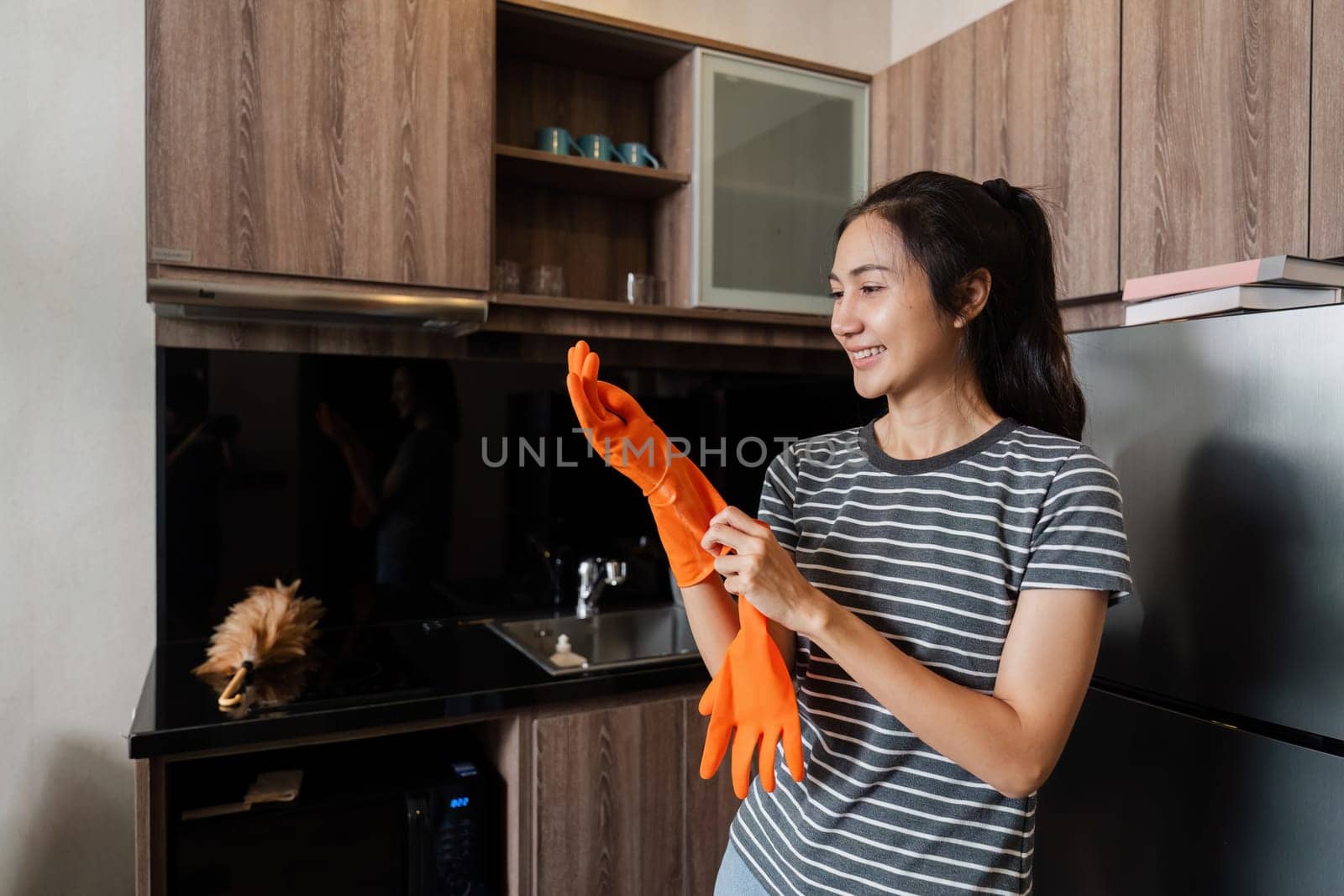 Female housekeeper smile and wearing glove, preparing to cleaning home by itchaznong