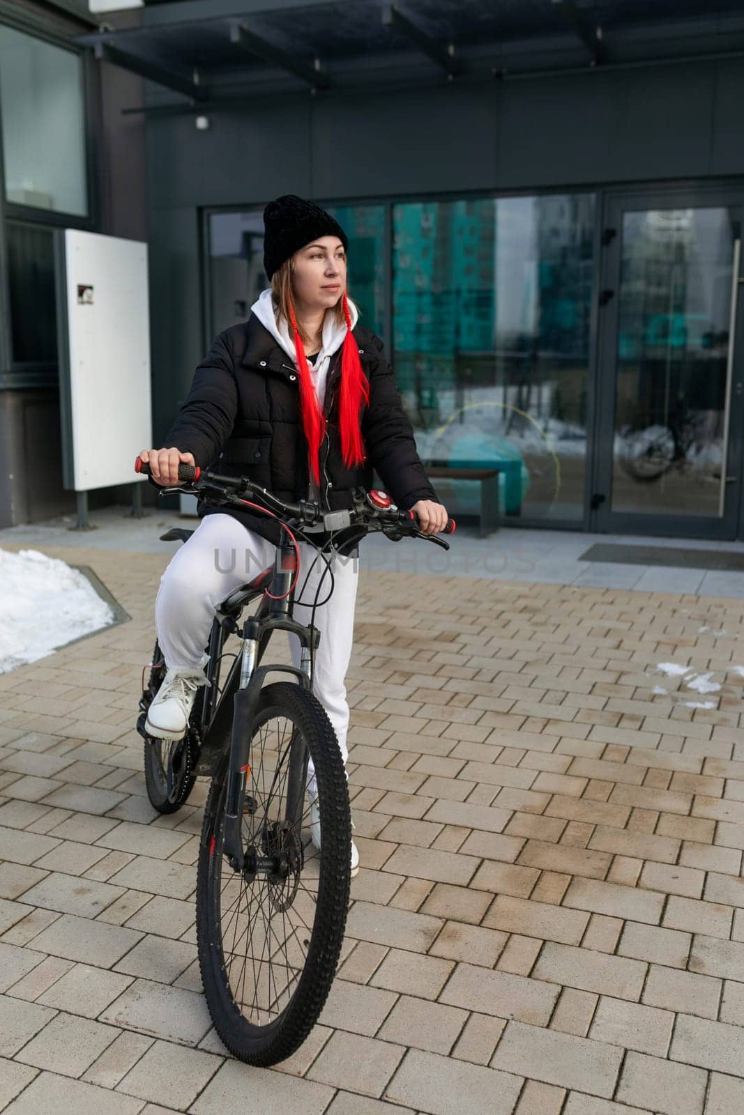 A woman took a rented bicycle with her outside in winter.
