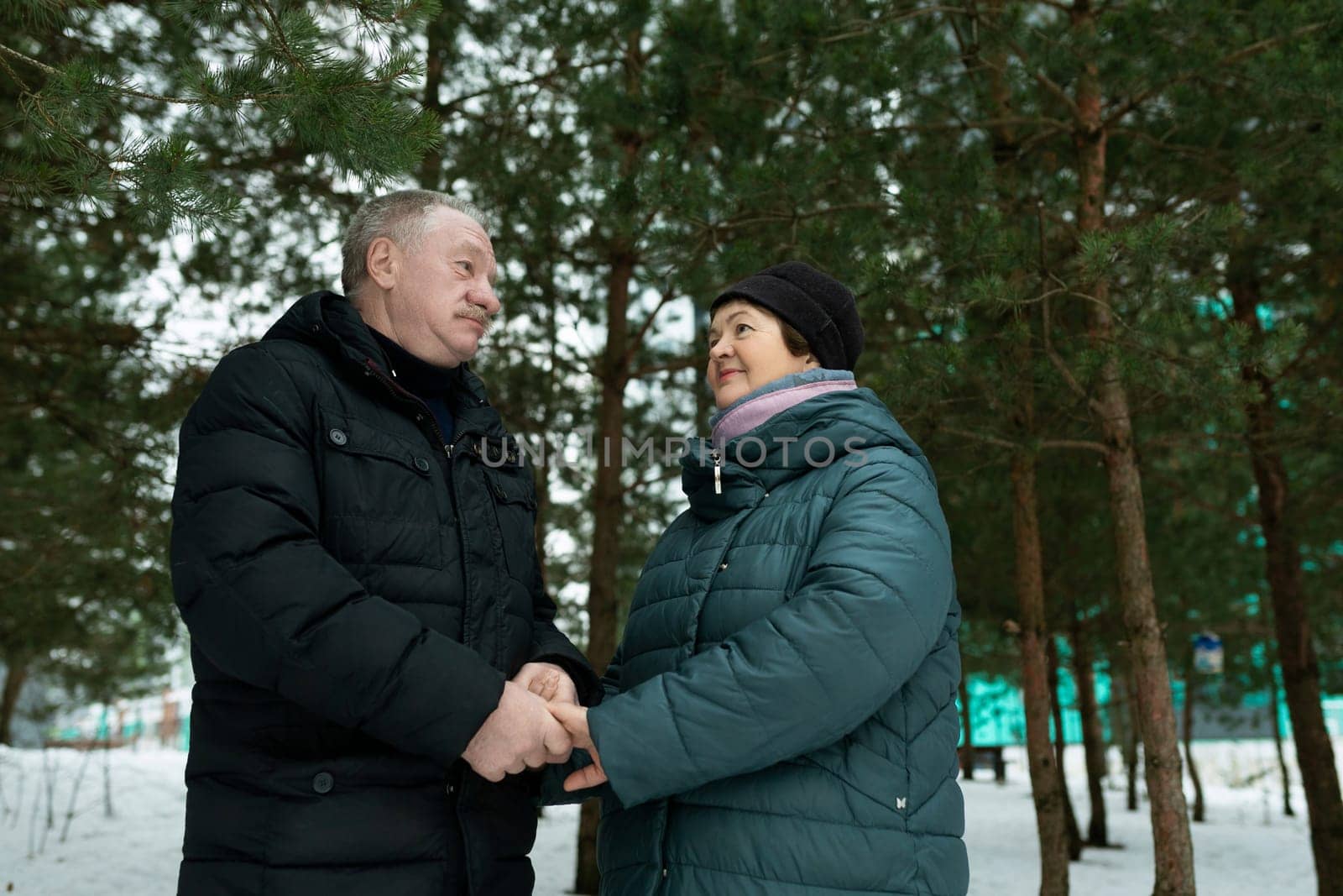 Cute retired couple going for a walk and holding hands together by TRMK