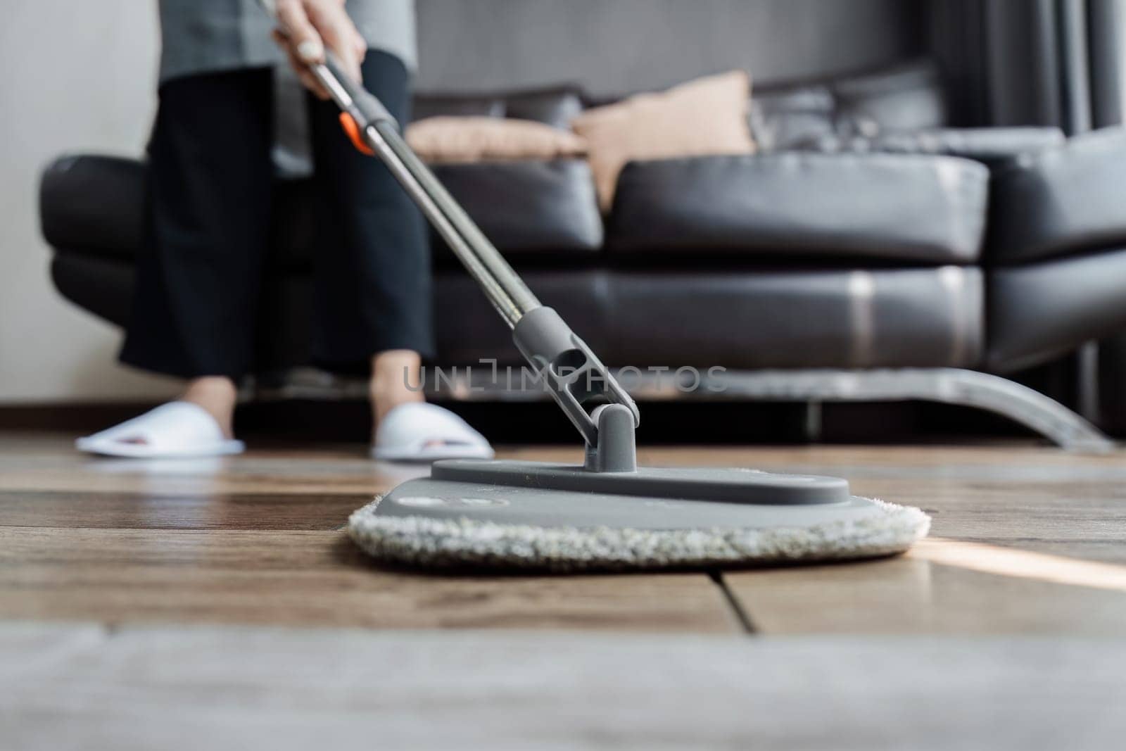 cleaning service housekeeper women swipe floor in living room. House cleaning service concept.