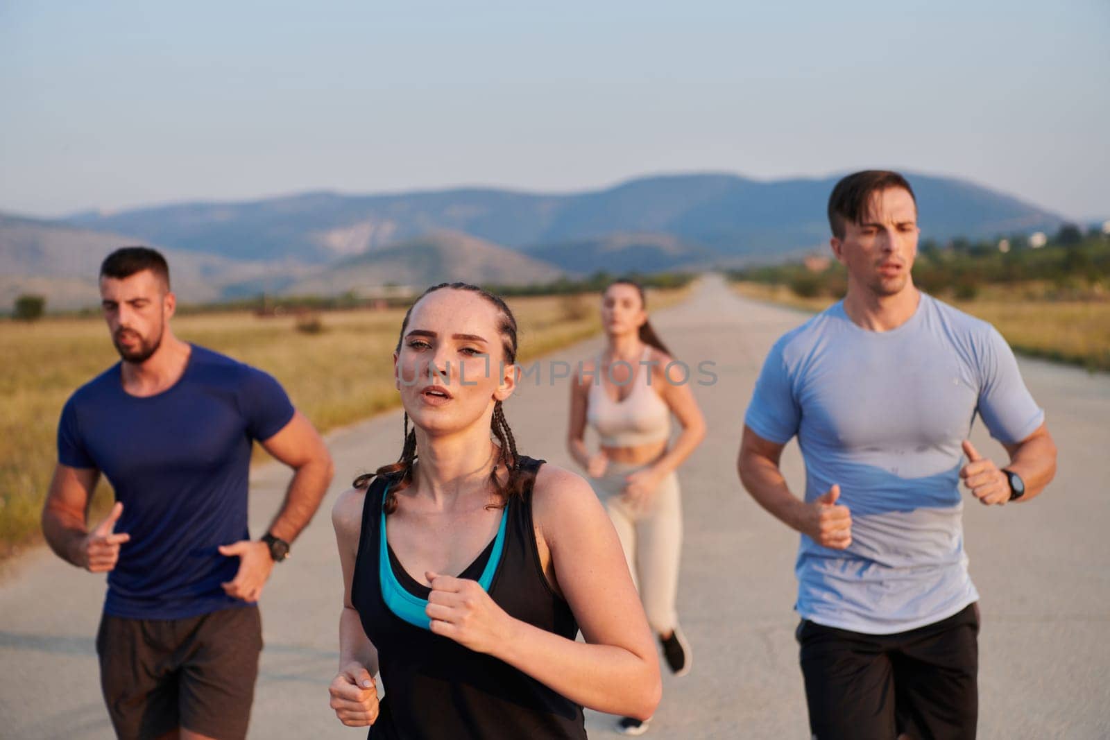 A group of friends maintains a healthy lifestyle by running outdoors on a sunny day, bonding over fitness and enjoying the energizing effects of exercise and nature by dotshock