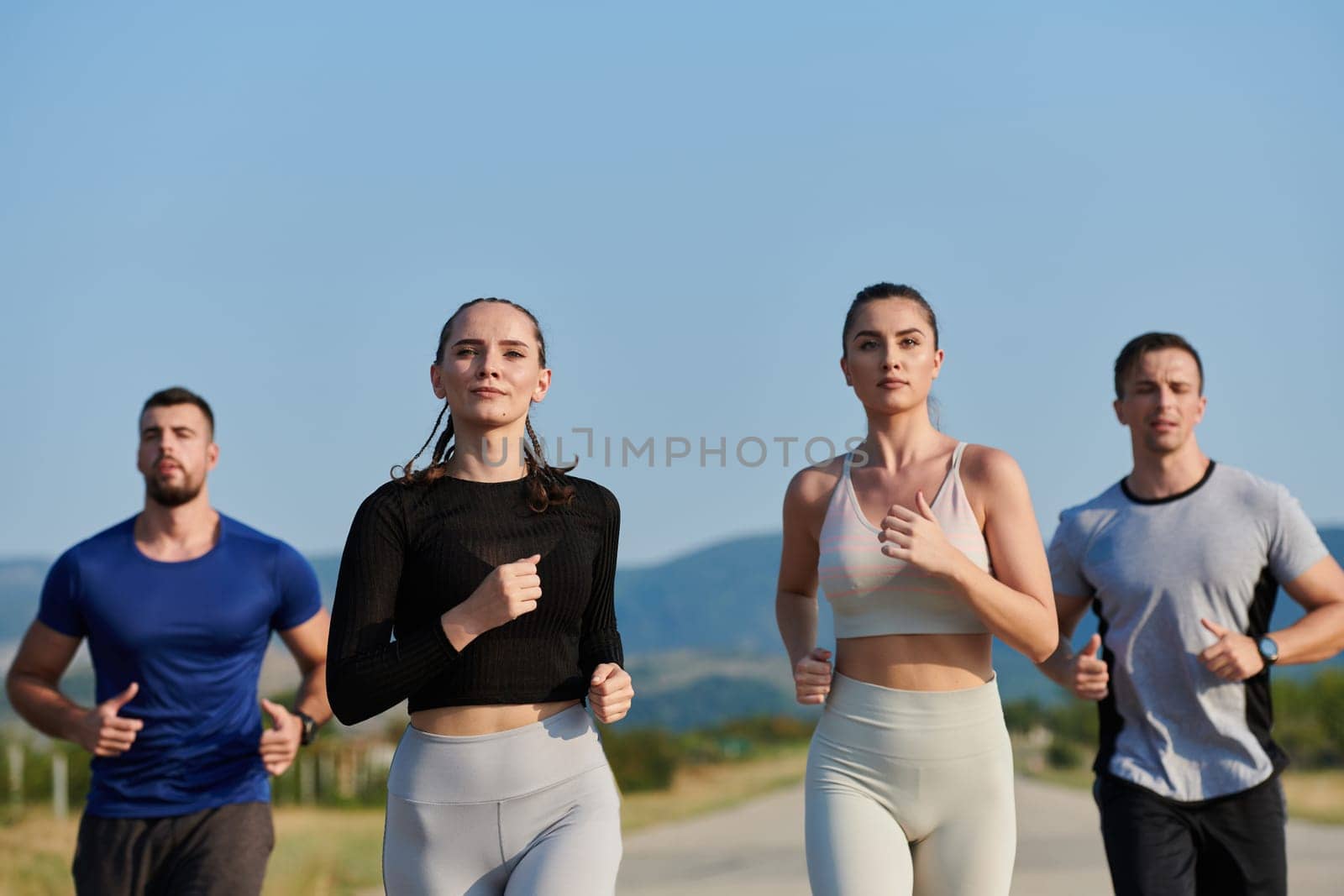 A group of friends maintains a healthy lifestyle by running outdoors on a sunny day, bonding over fitness and enjoying the energizing effects of exercise and nature by dotshock