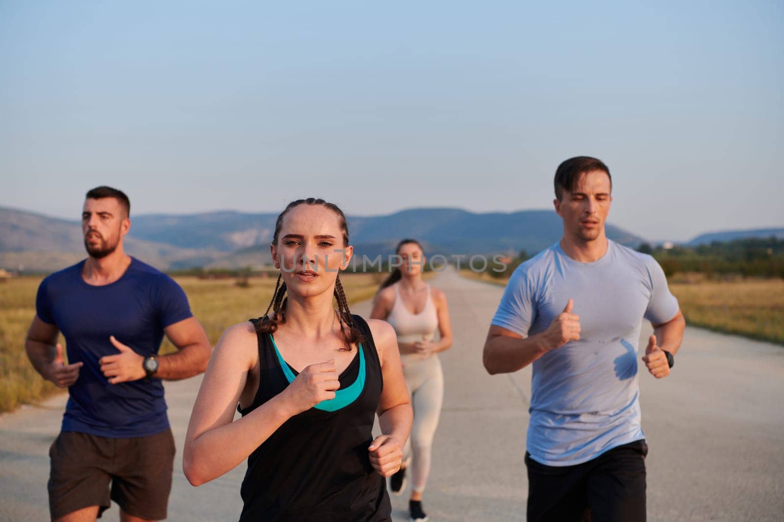 A group of friends maintains a healthy lifestyle by running outdoors on a sunny day, bonding over fitness and enjoying the energizing effects of exercise and nature by dotshock