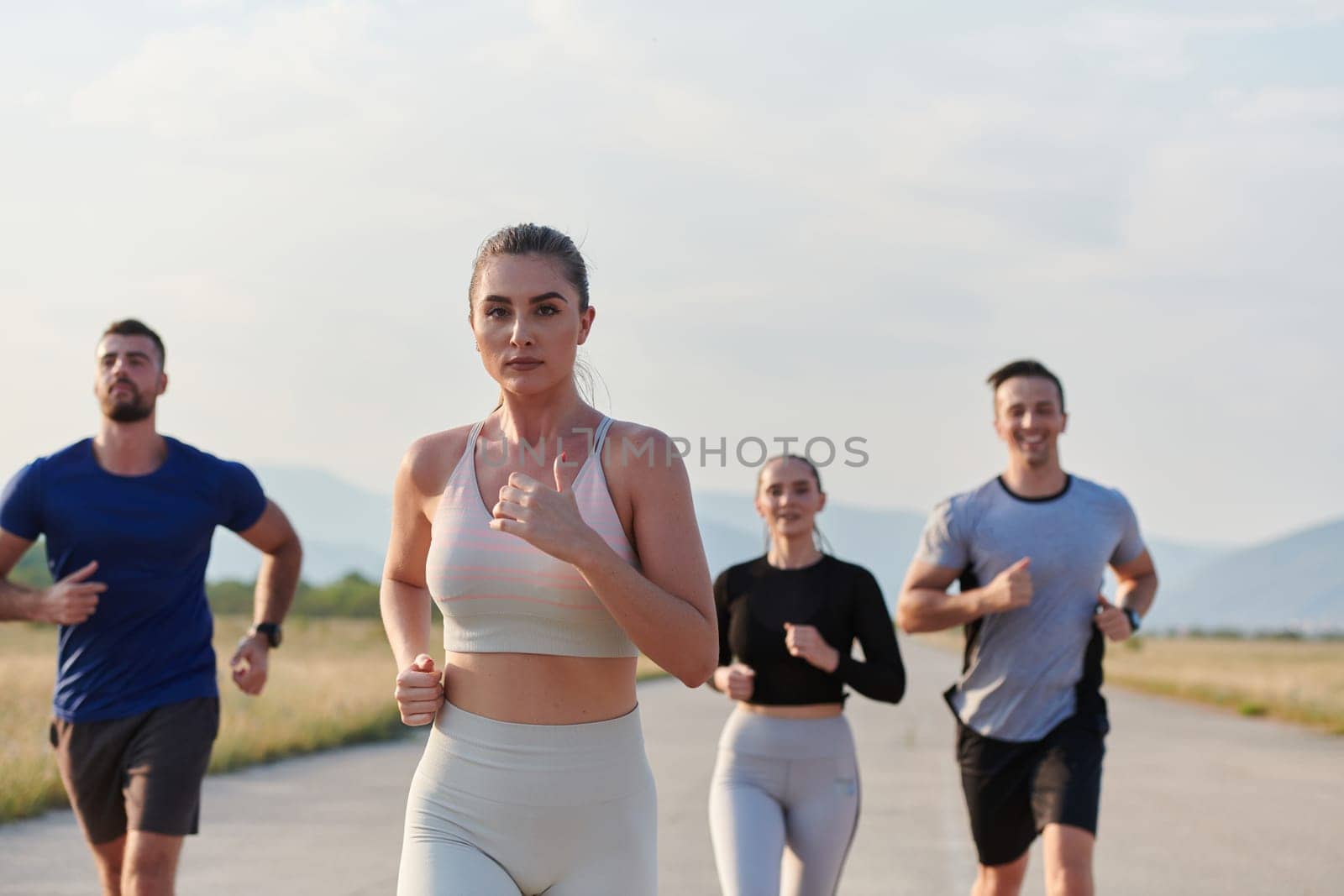 A group of friends maintains a healthy lifestyle by running outdoors on a sunny day, bonding over fitness and enjoying the energizing effects of exercise and nature by dotshock