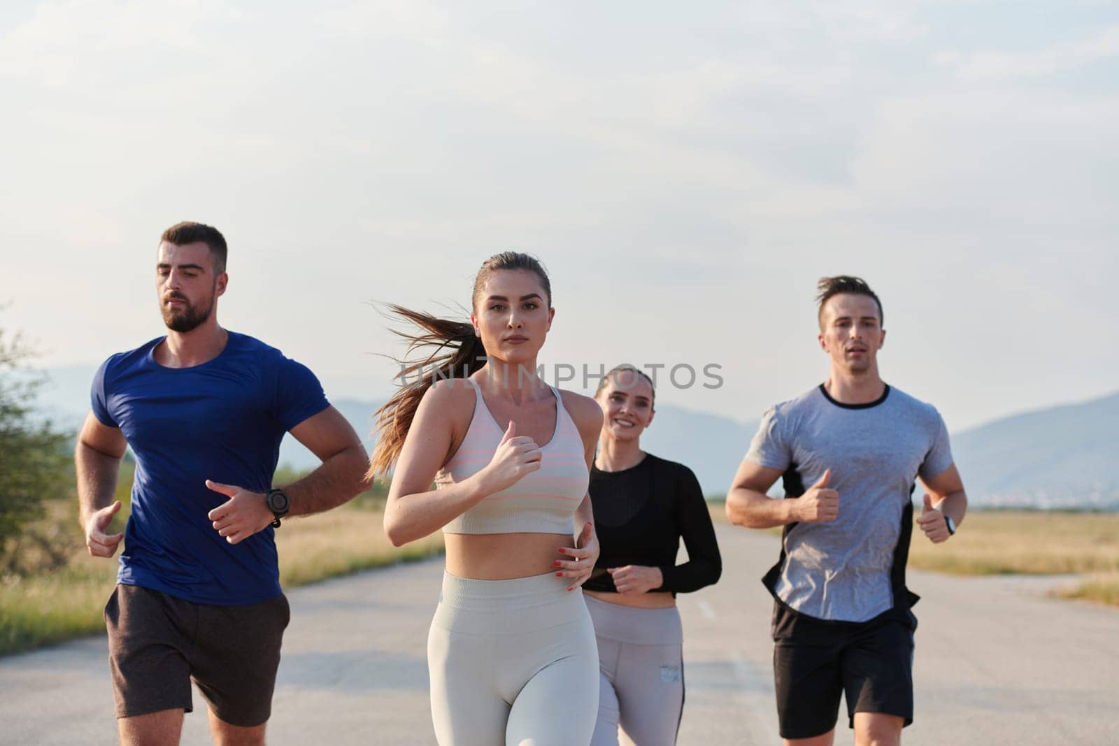 A group of friends maintains a healthy lifestyle by running outdoors on a sunny day, bonding over fitness and enjoying the energizing effects of exercise and nature by dotshock