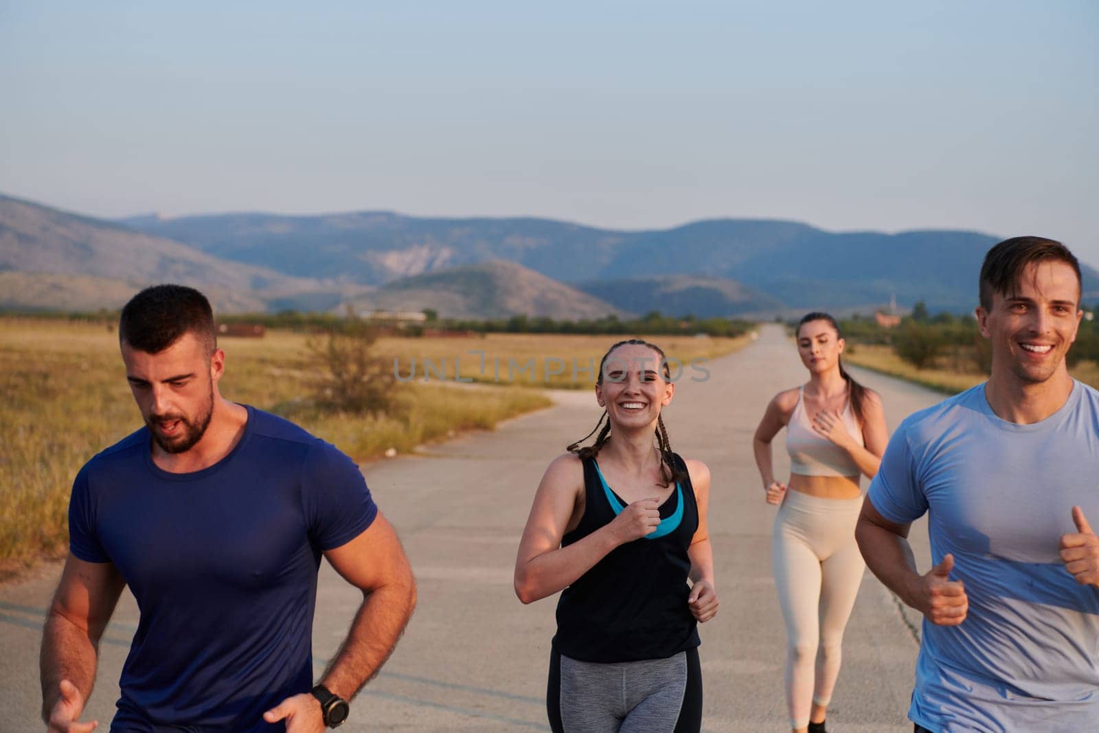 A group of friends maintains a healthy lifestyle by running outdoors on a sunny day, bonding over fitness and enjoying the energizing effects of exercise and nature.