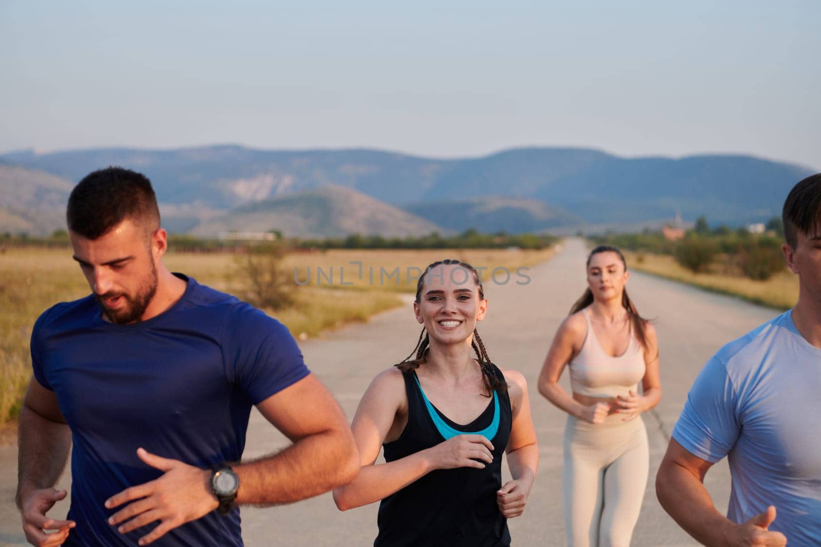 A group of friends maintains a healthy lifestyle by running outdoors on a sunny day, bonding over fitness and enjoying the energizing effects of exercise and nature by dotshock