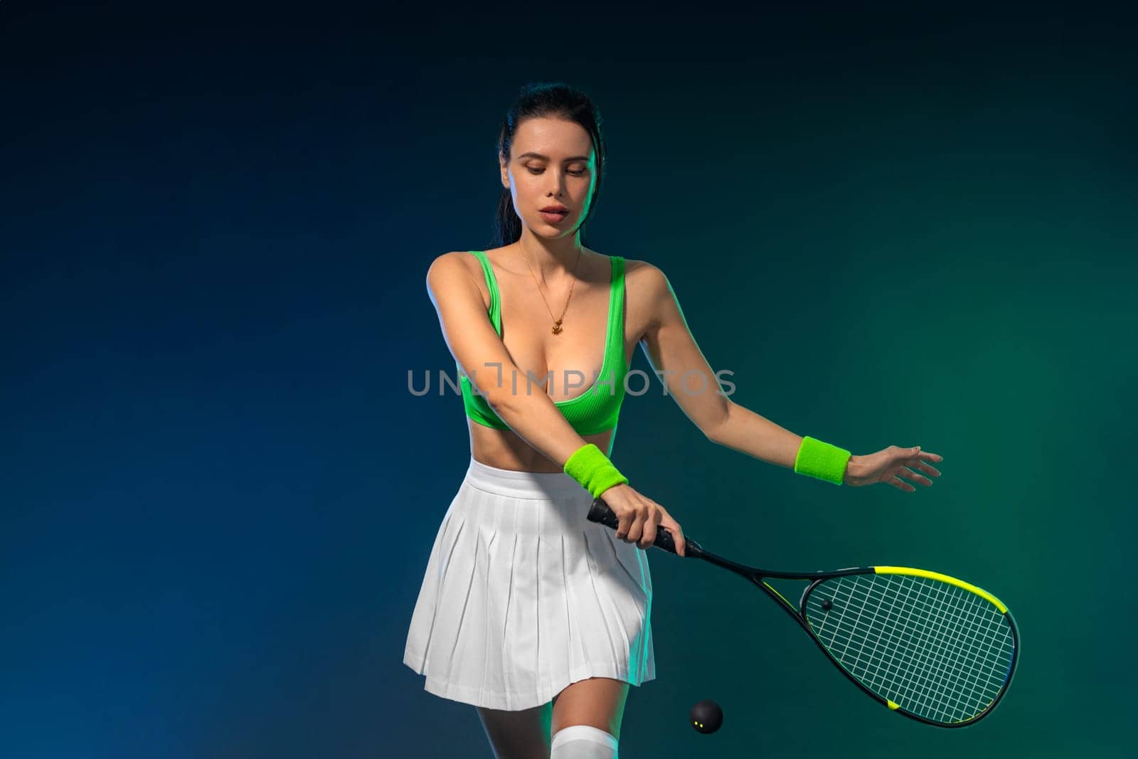 Squash player on a squash court with racket. Man athlete with racket on court with neon colors. Sport concept. Download a high quality photo for the design of a sports app or betting site