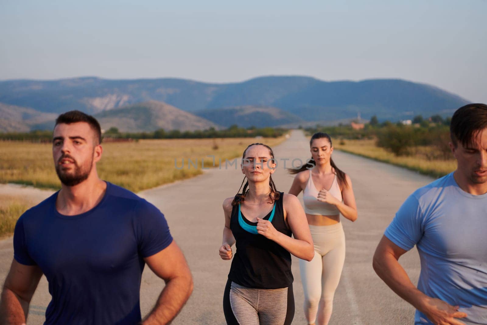 A group of friends maintains a healthy lifestyle by running outdoors on a sunny day, bonding over fitness and enjoying the energizing effects of exercise and nature by dotshock