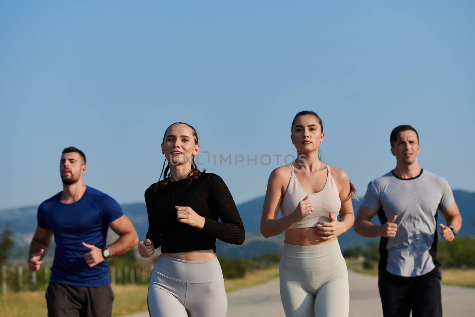 A group of friends maintains a healthy lifestyle by running outdoors on a sunny day, bonding over fitness and enjoying the energizing effects of exercise and nature.