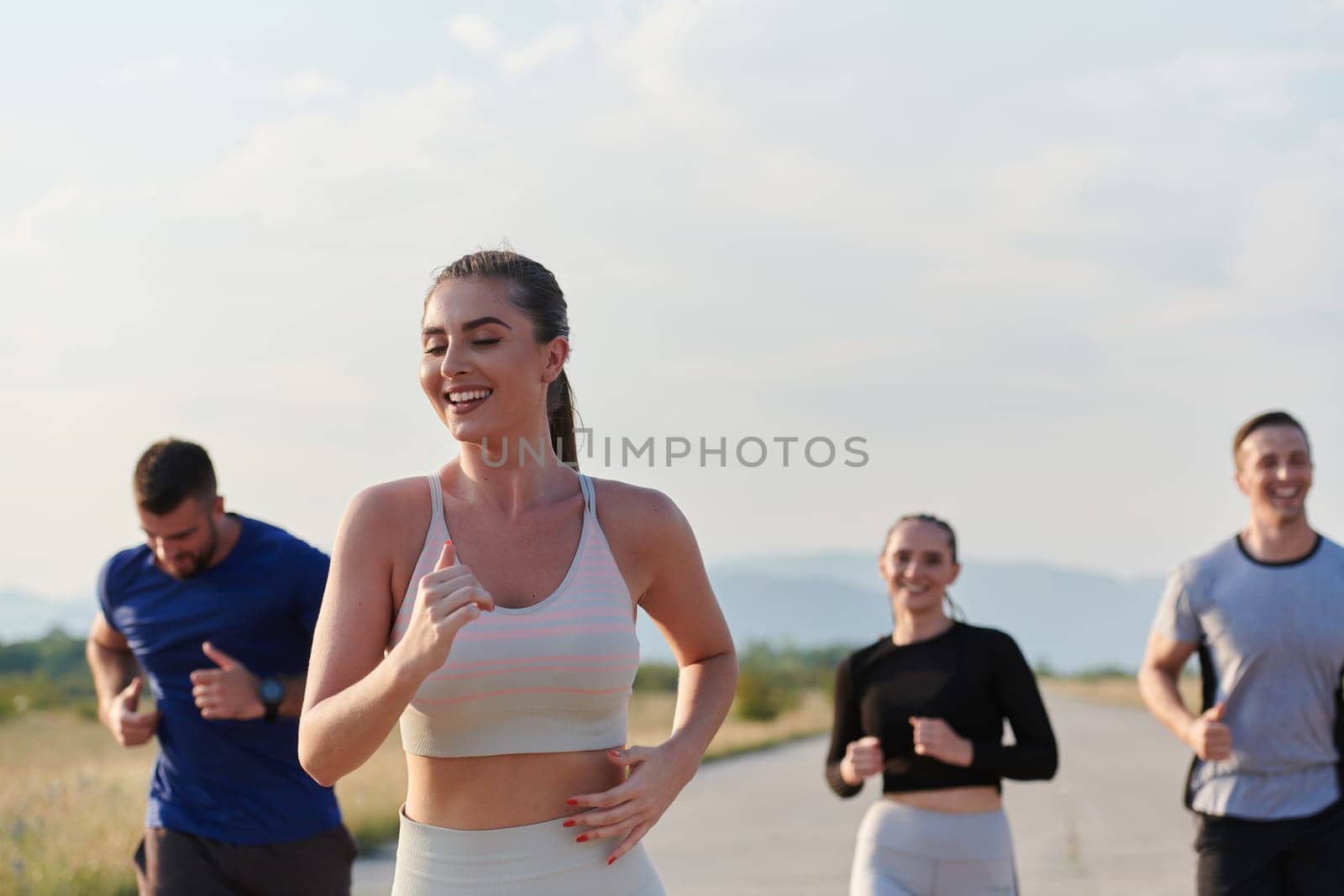 A group of friends maintains a healthy lifestyle by running outdoors on a sunny day, bonding over fitness and enjoying the energizing effects of exercise and nature.