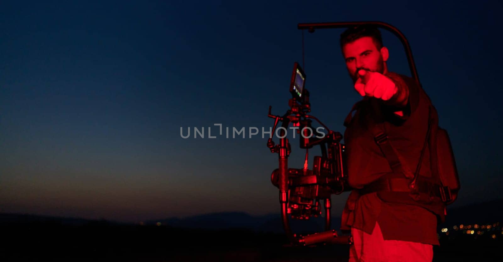 Nighttime Capture: Professional Videographer Films Athletes Running in Red-Lit Darkness by dotshock