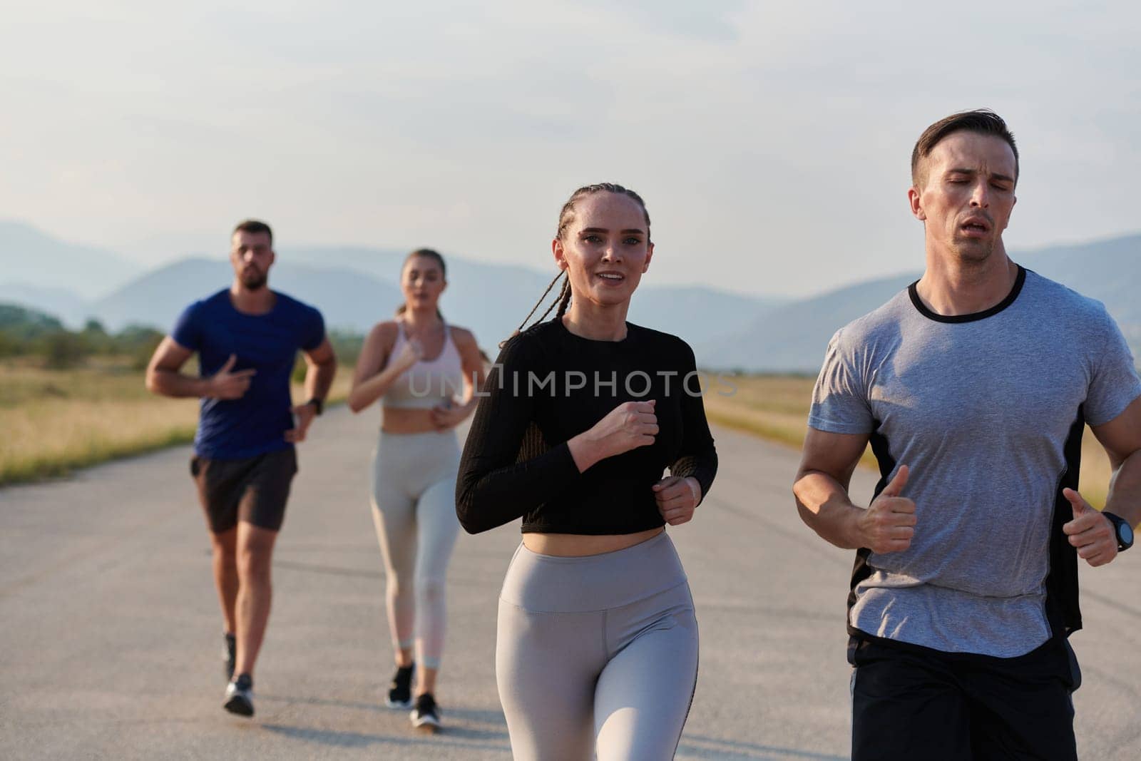 A group of friends maintains a healthy lifestyle by running outdoors on a sunny day, bonding over fitness and enjoying the energizing effects of exercise and nature by dotshock