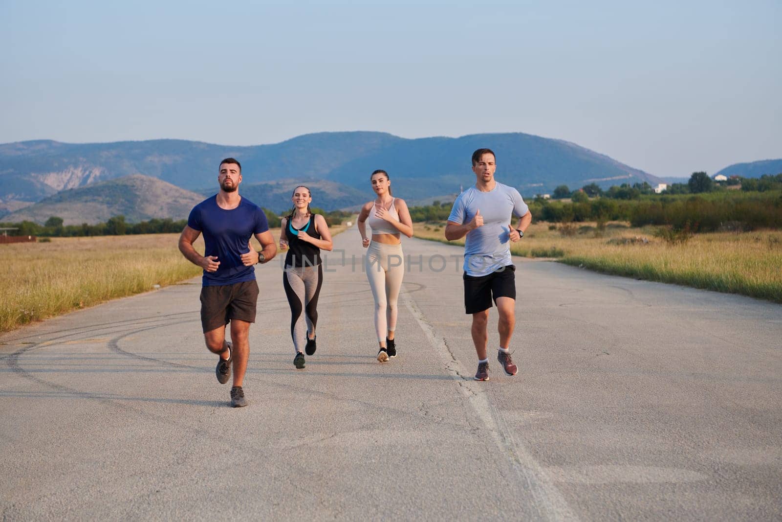 A group of friends maintains a healthy lifestyle by running outdoors on a sunny day, bonding over fitness and enjoying the energizing effects of exercise and nature by dotshock