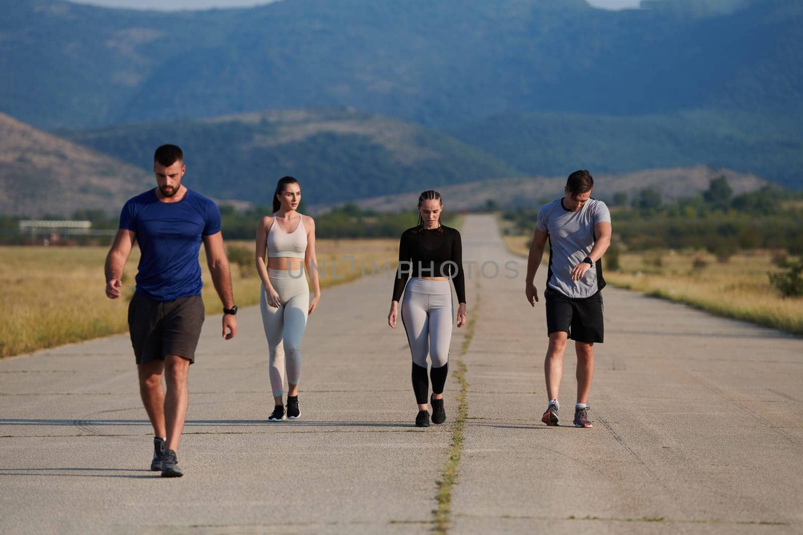 A group of friends maintains a healthy lifestyle by running outdoors on a sunny day, bonding over fitness and enjoying the energizing effects of exercise and nature by dotshock