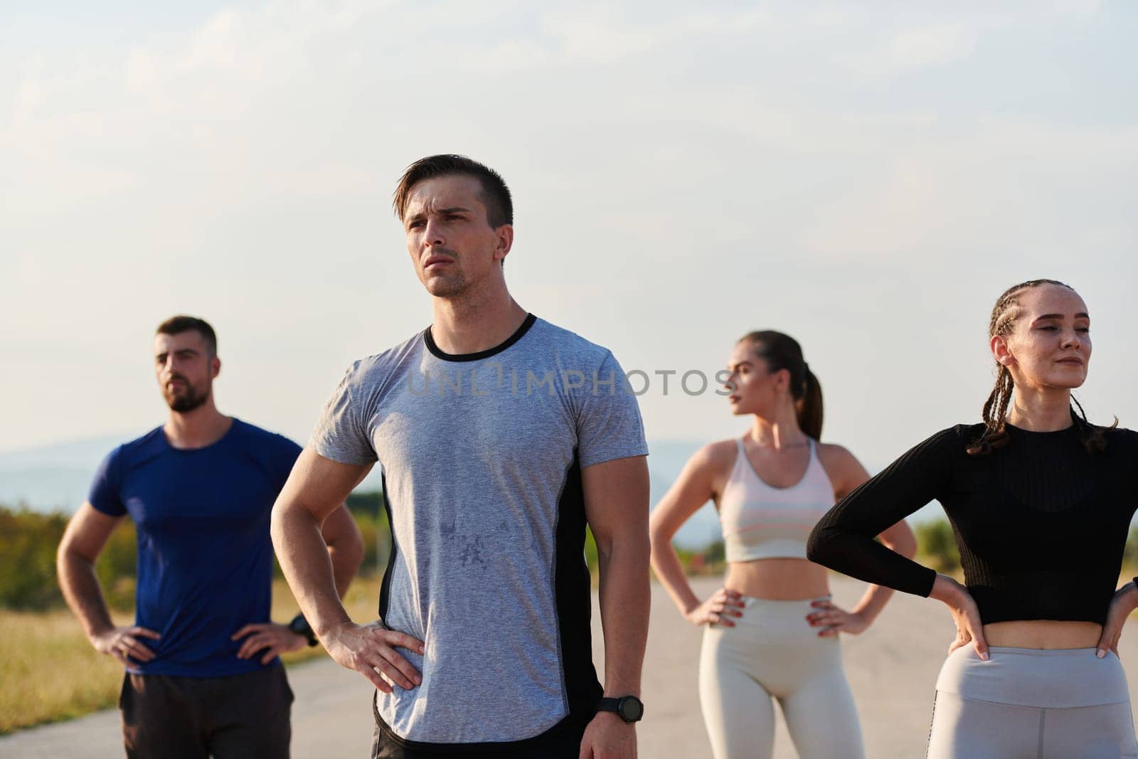 In a dynamic display of unity and preparation, a diverse group of athletes warm up together, readying themselves for a challenging running endeavor.