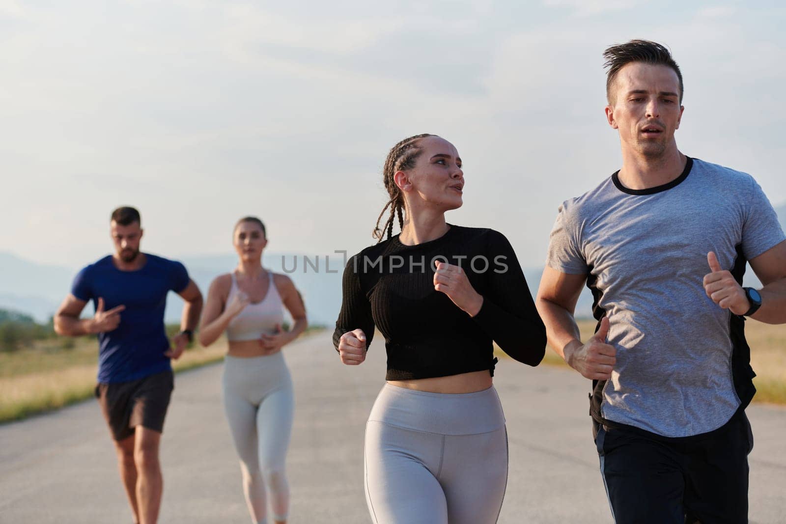 A group of friends maintains a healthy lifestyle by running outdoors on a sunny day, bonding over fitness and enjoying the energizing effects of exercise and nature.